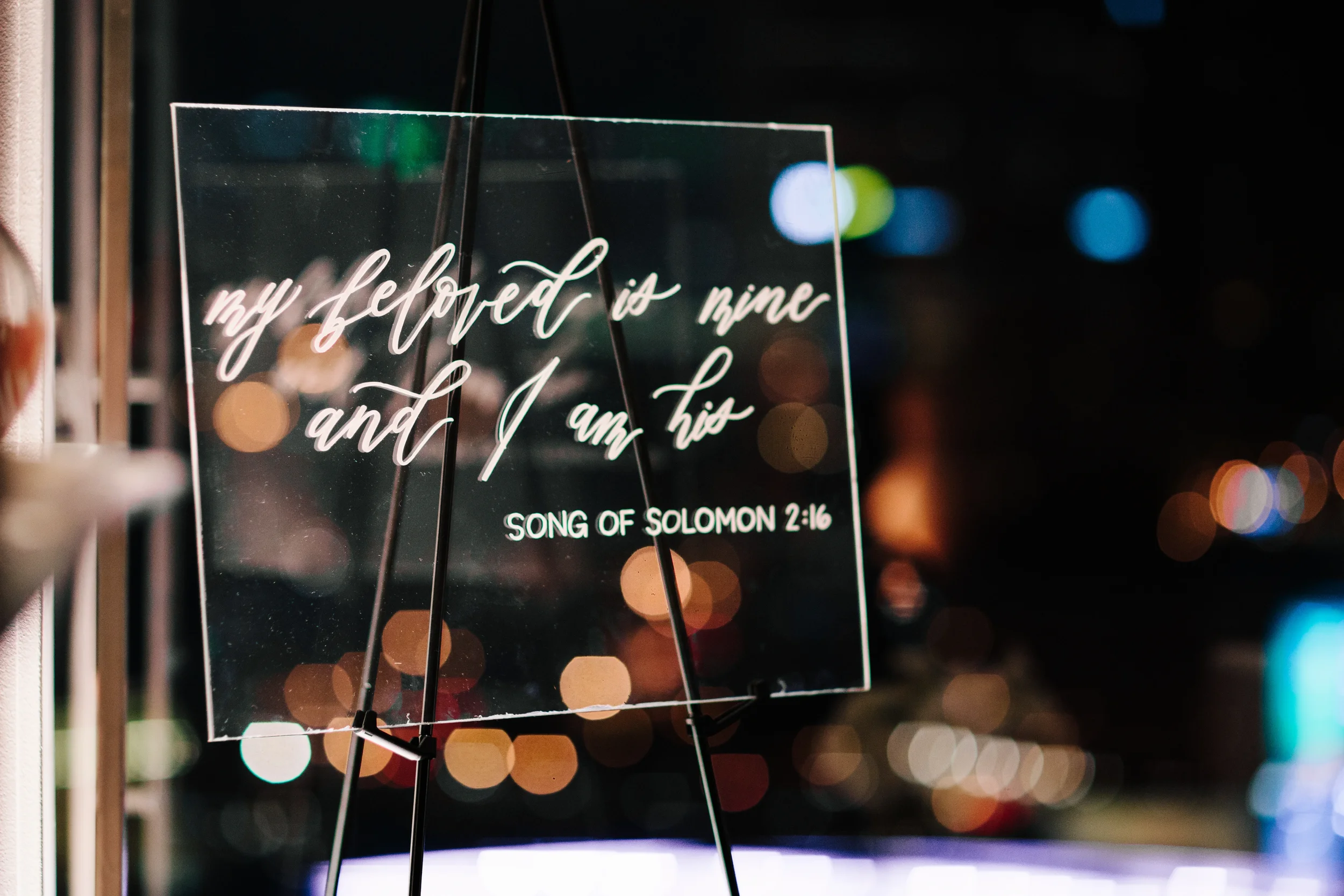 Modern acrylic ceremony quote sign featuring custom white ink Bible verse lettering.