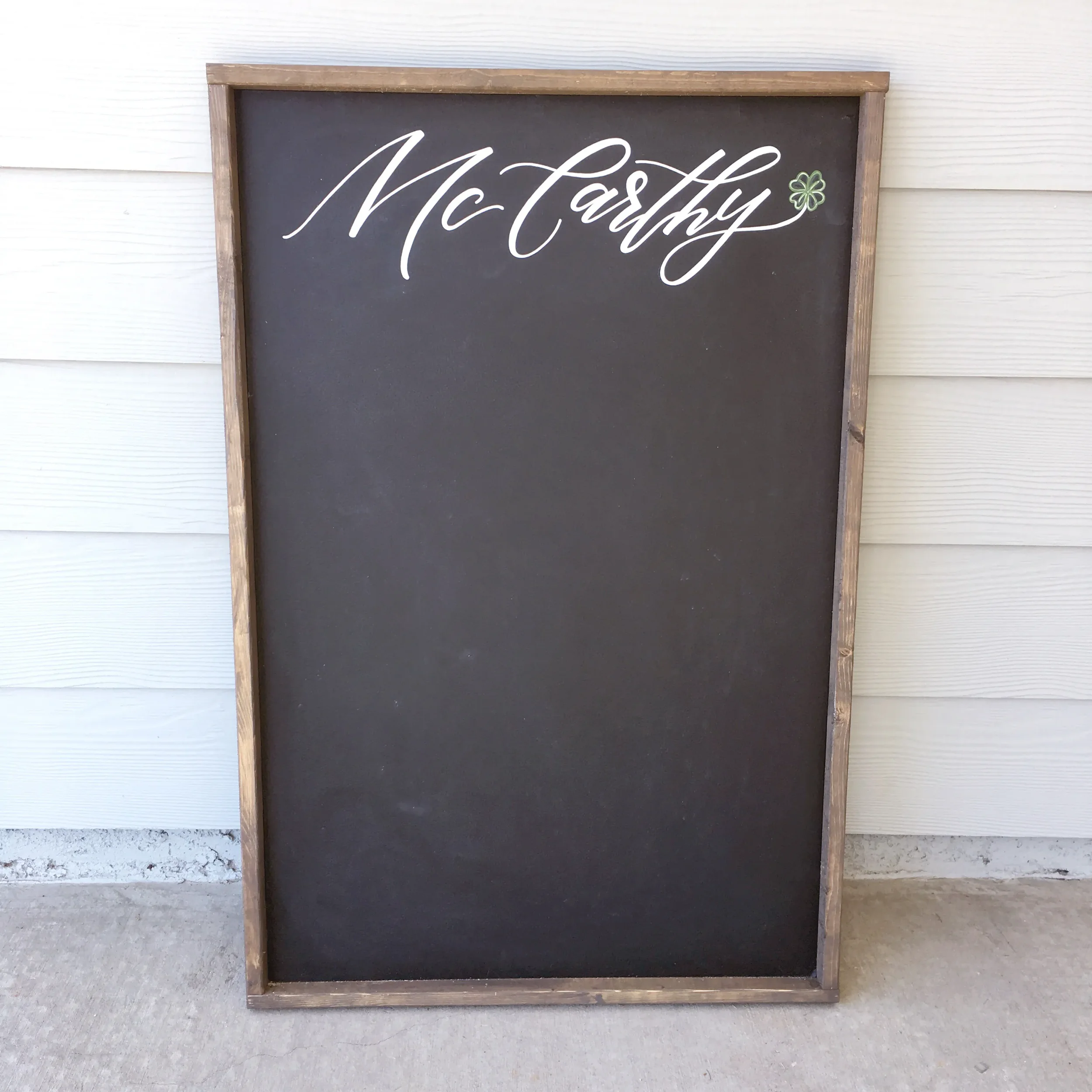 Custom wooden framed chalkboard displaying family name on top in white calligraphy for family hub.