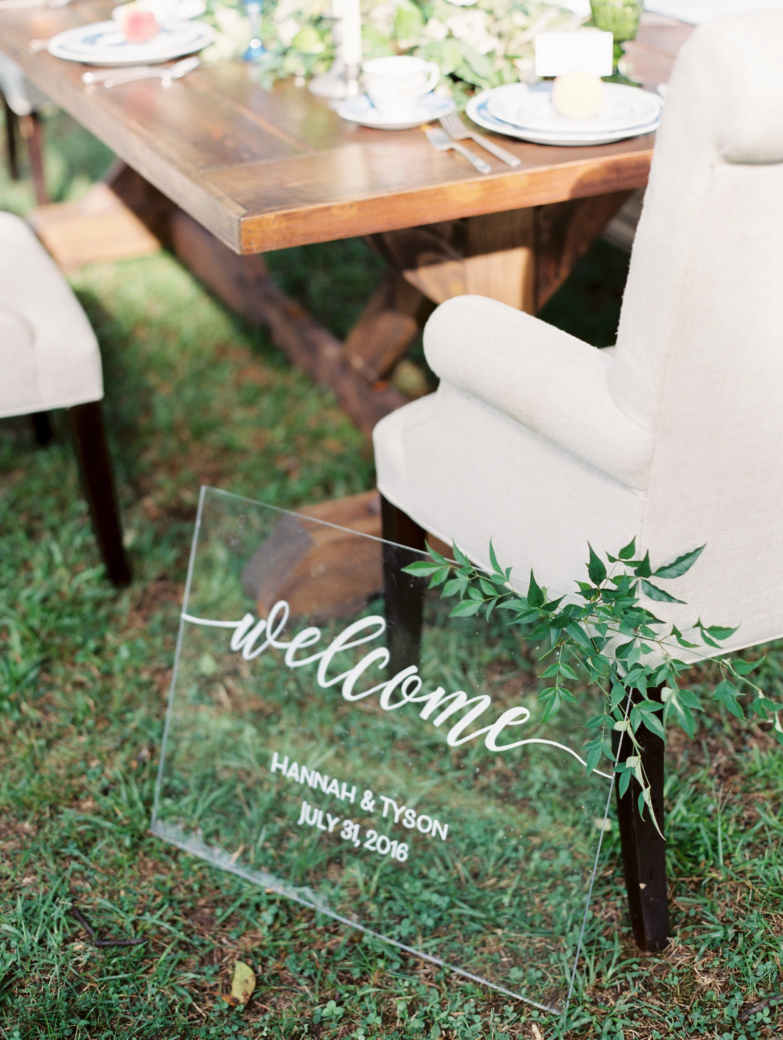 Greet your guests with a contemporary flair using a clear acrylic wedding welcome sign. This minimalist design relies on clean, fluid white script calligraphy to create an airy, upscale entry piece that perfectly complements a modern indoor reception