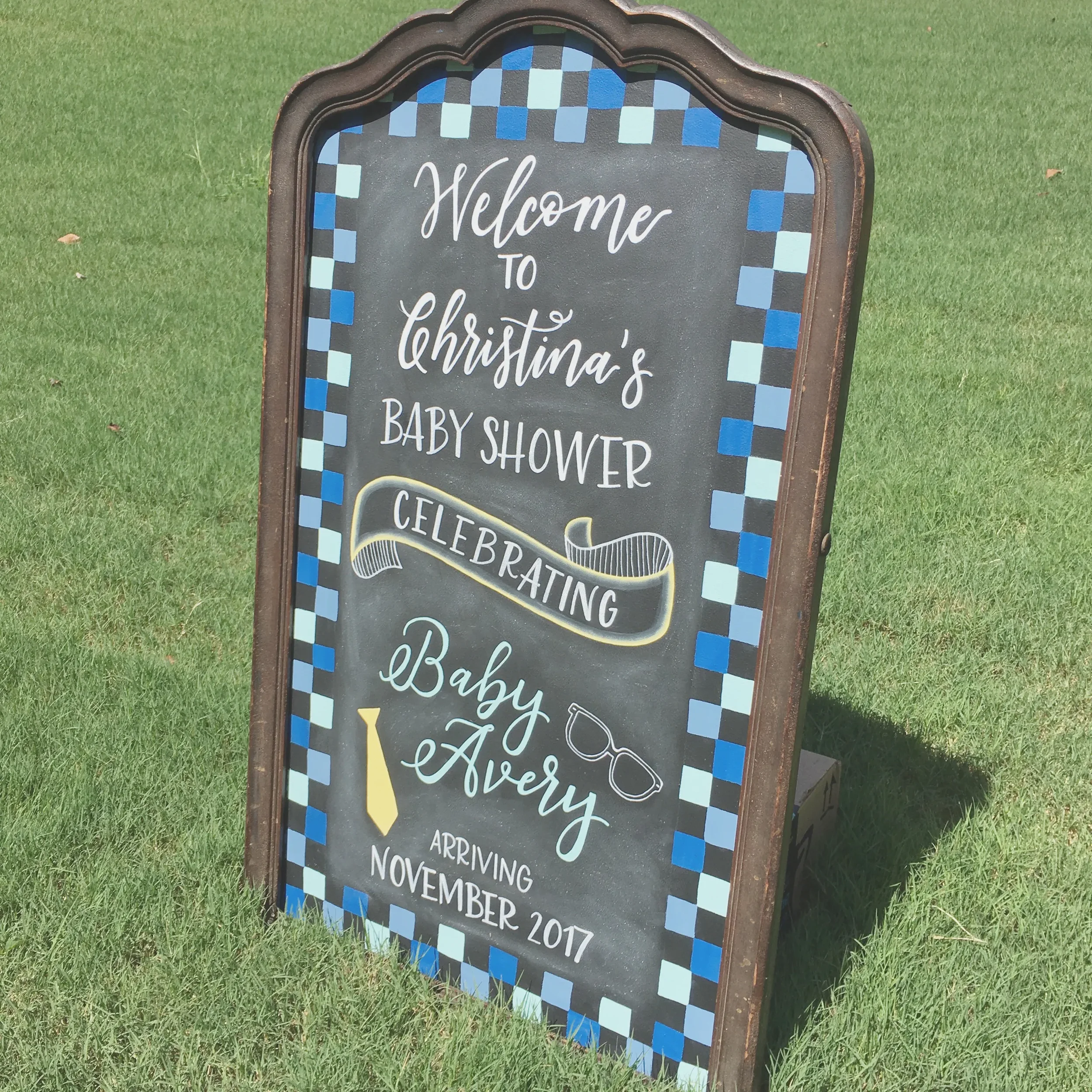 Celebrate the mama-to-be with an eye-catching, custom-designed baby shower chalkboard sign. Featuring a vintage frame, modern script calligraphy and hand-lettering, and colorful hand-drawn illustrations and checkered border. This welcoming sign adds 