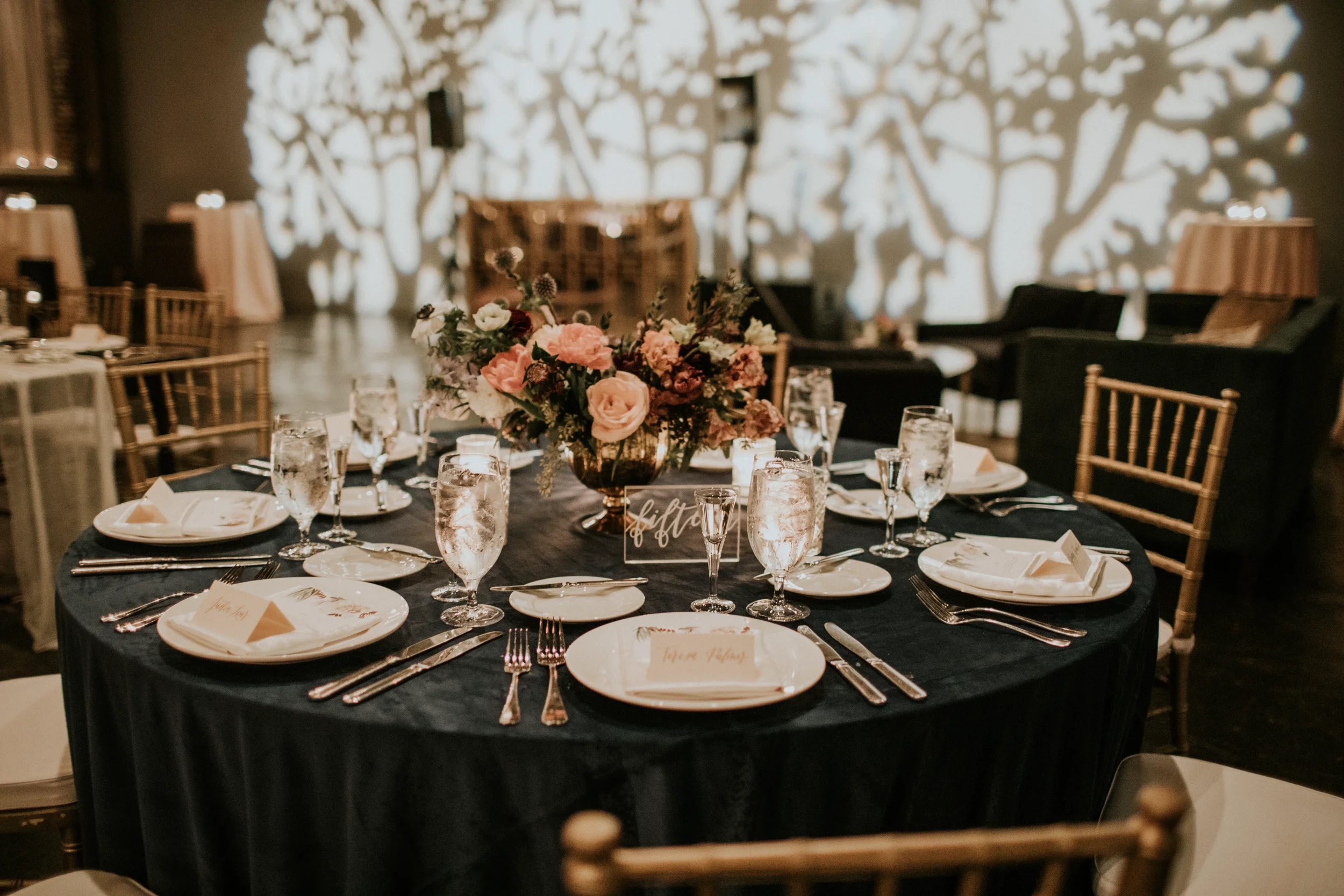 It's all in the details. Bring a modern, elegant touch to a rustic or moody tablescape with clear acrylic table numbers. Styled here with romantic taper candles, and rich, layered florals, our hand-lettered signs seamlessly blend functionality with l