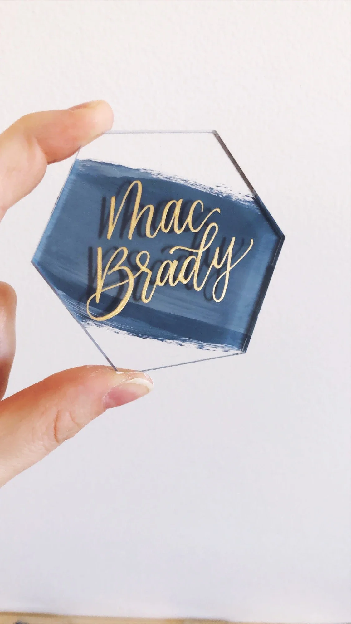 Clear acrylic, navy brushed back hexagon tile place cards with gold calligraphy ink.