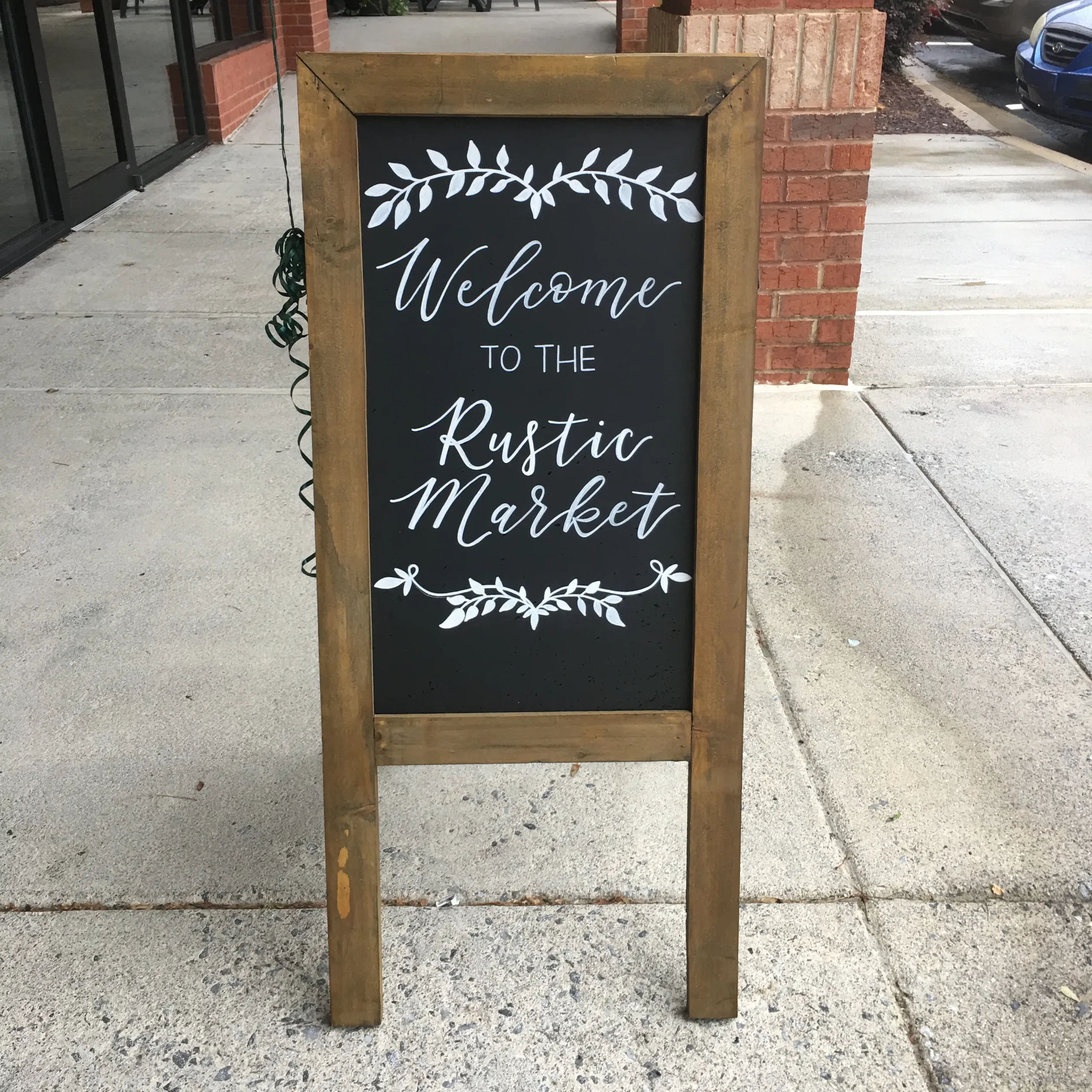 Drive organic foot traffic straight through your boutique doors with a rustic wooden A-frame sidewalk chalkboard sign. This eye-catching retail sandwich board is a creative, high-conversion tool to showcase new seasonal arrivals.