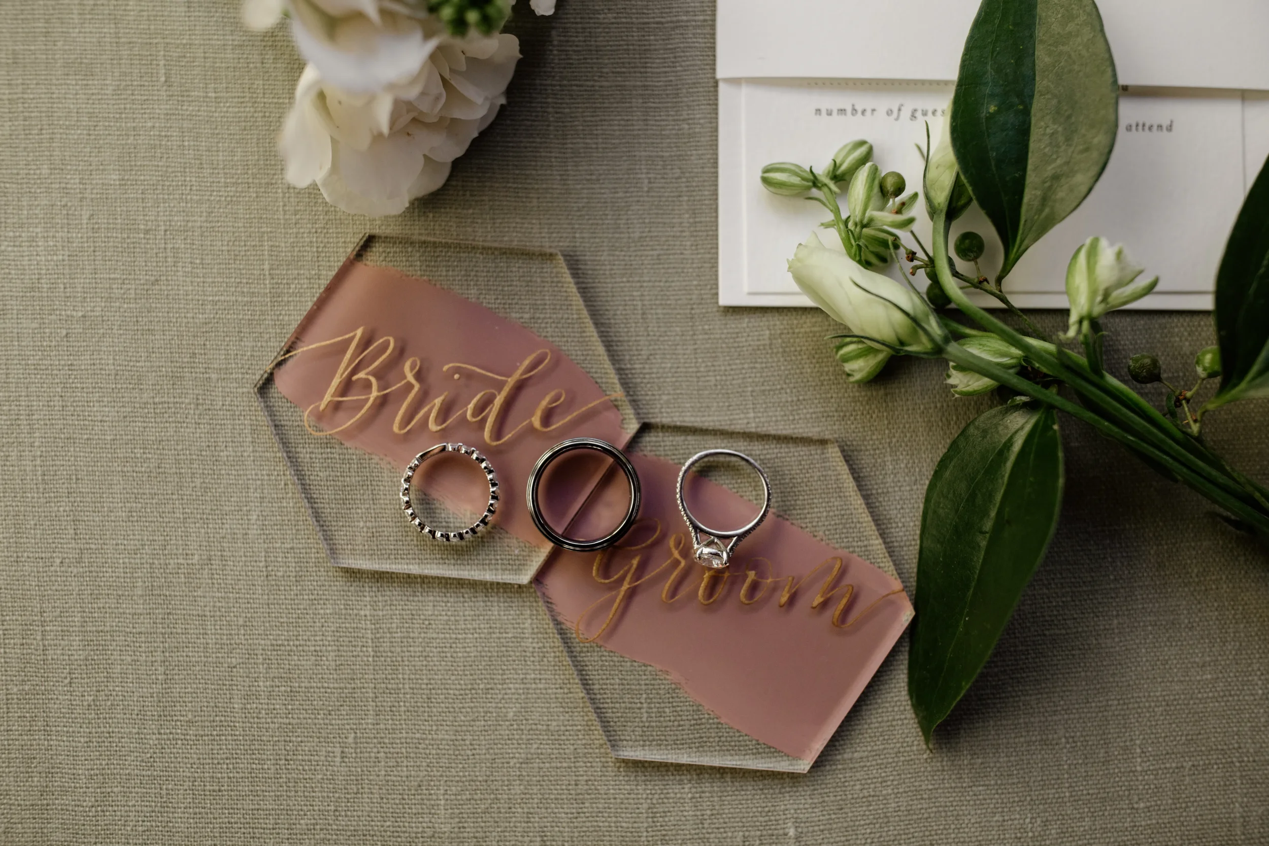 Painted back acrylic hexagon bride and groom place card with gold script calligraphy.