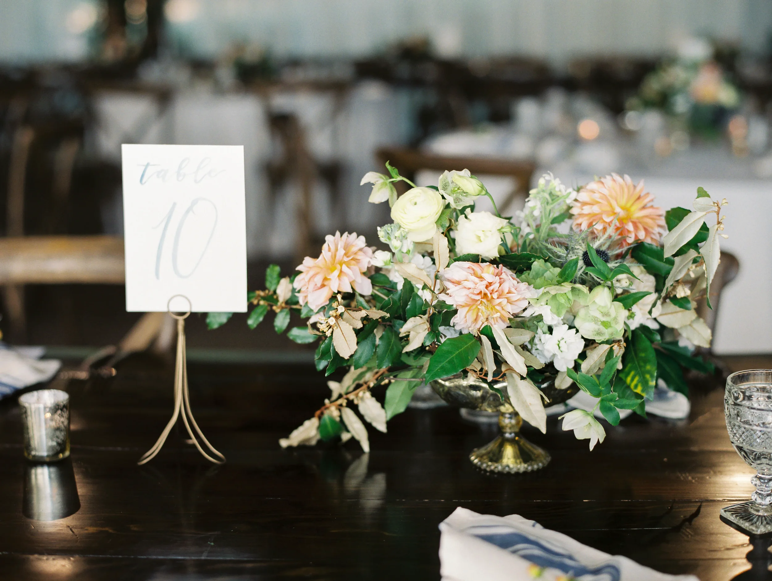 Light dusty blue watercolor script table numbers on clean white paper cards.