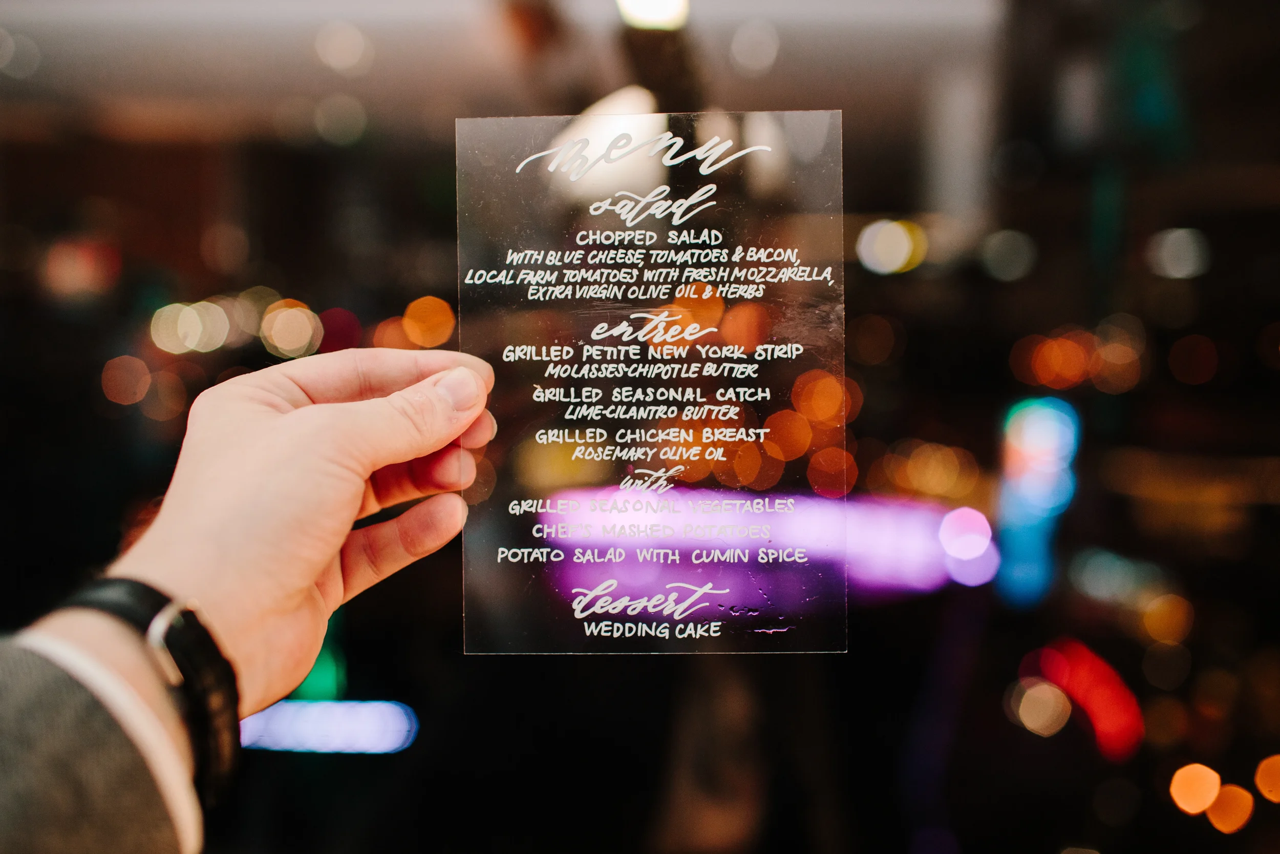 Contemporary transparent acrylic reception menu displaying wedding dinner courses.