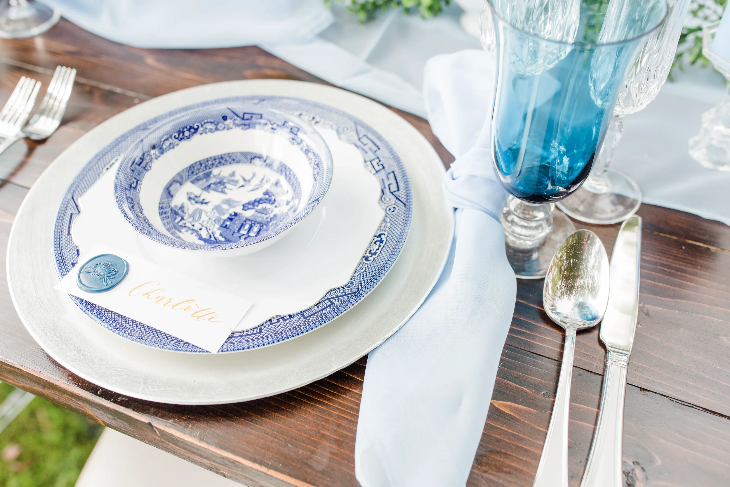 Traditional blue and white pattern china bowl with a blue wax seal name card lettered in gold script.