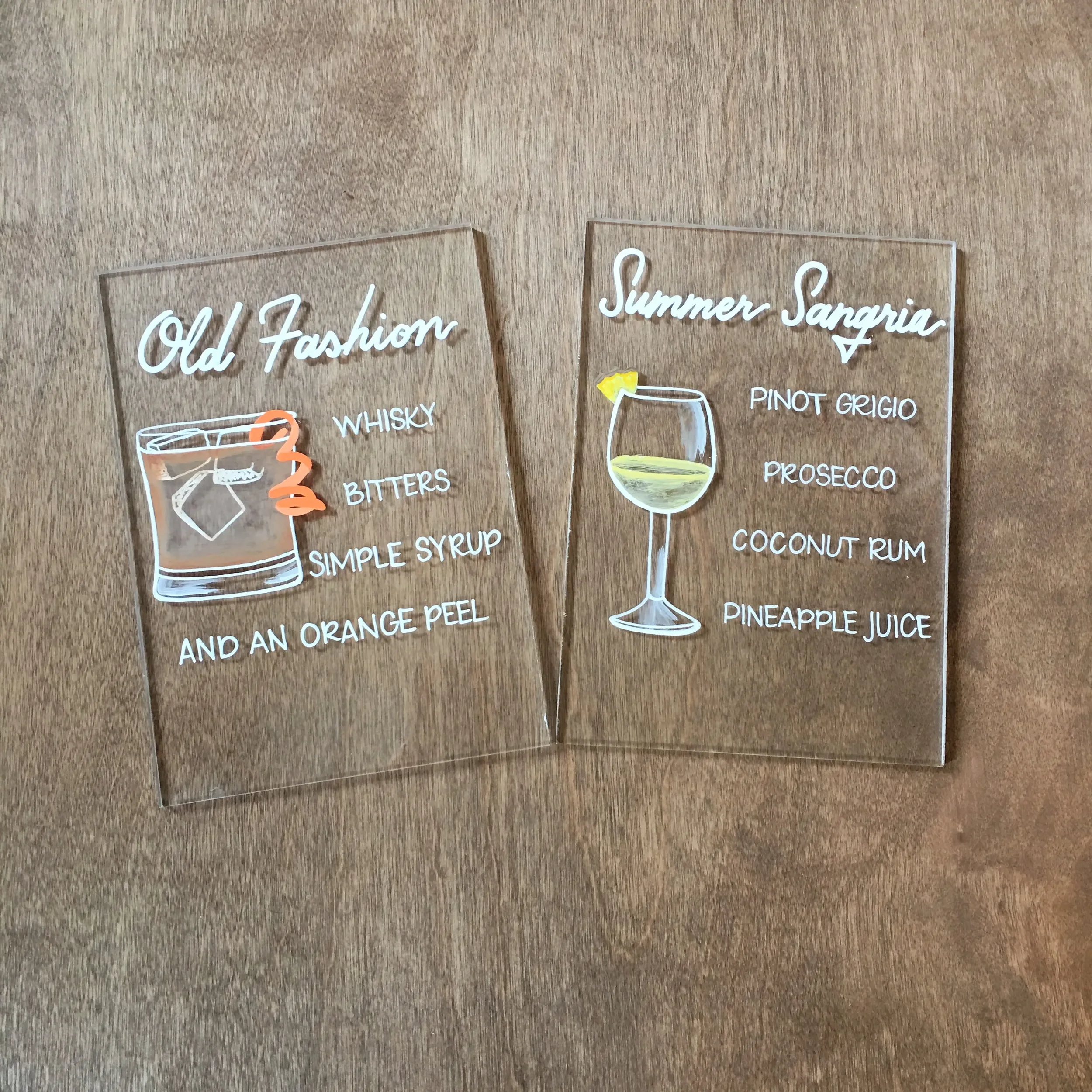 Hand-painted signature cocktail signs with retro hand-lettering in white.