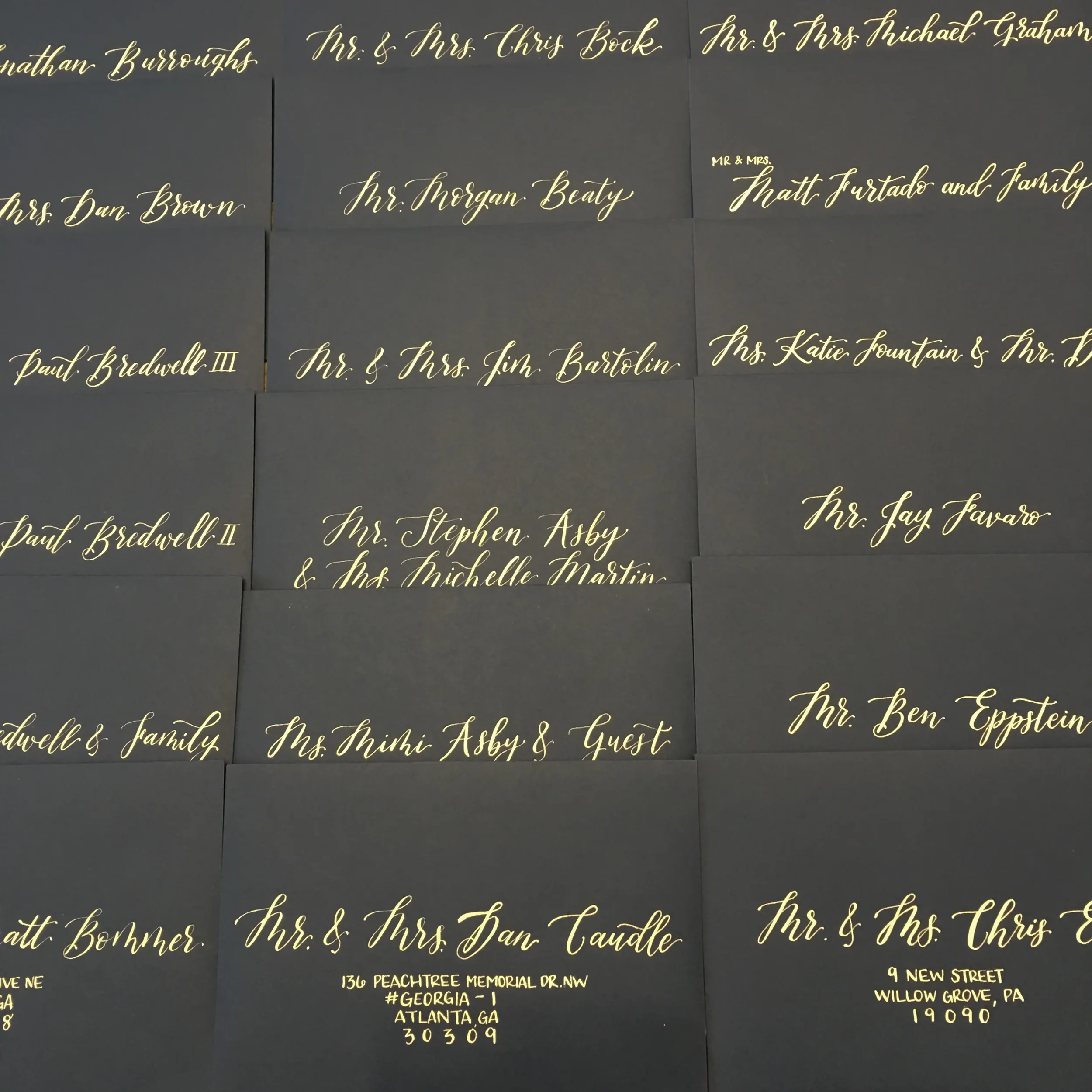 Black wedding guest envelope with metallic gold calligraphy ink for a modern wedding celebration.