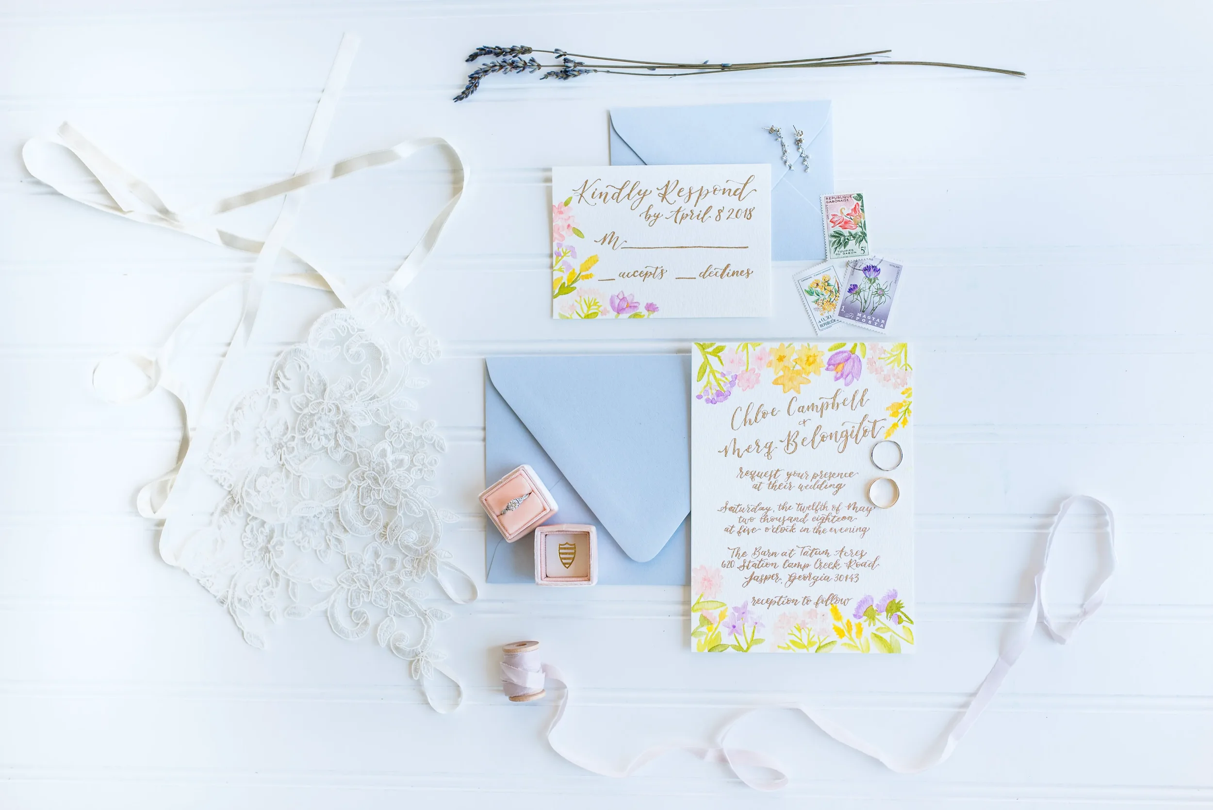 Set a whimsical, fine-art tone for your celebration with custom day of wedding invitations and stationery suites. Featuring hand-painted watercolor florals, elegant gold calligraphy, and soft pastel envelopes, this flat lay shows how every detail can