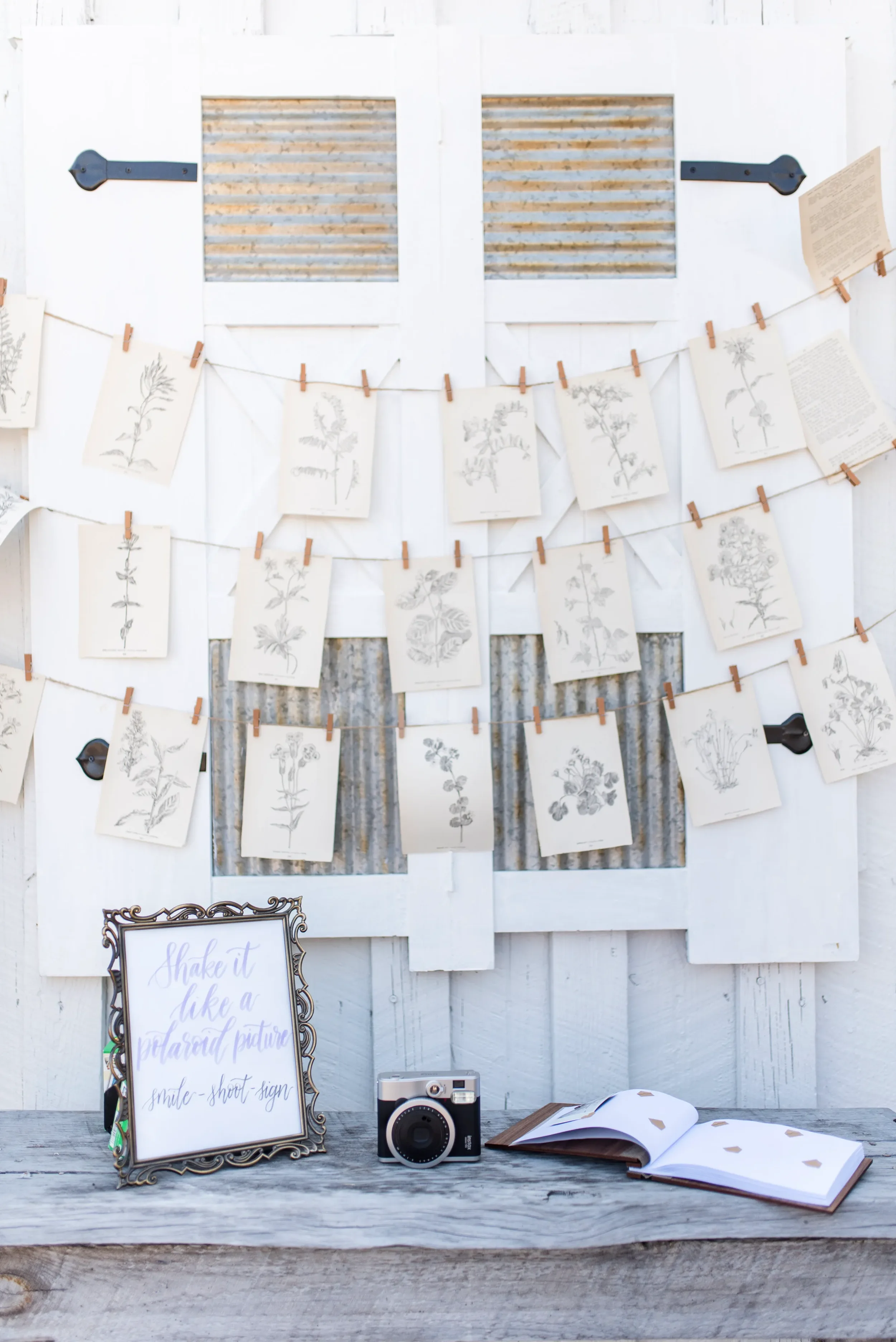 Hand-lettered polaroid photo guestbook sign in a vintage gold frame for an outdoor Georgia wedding.