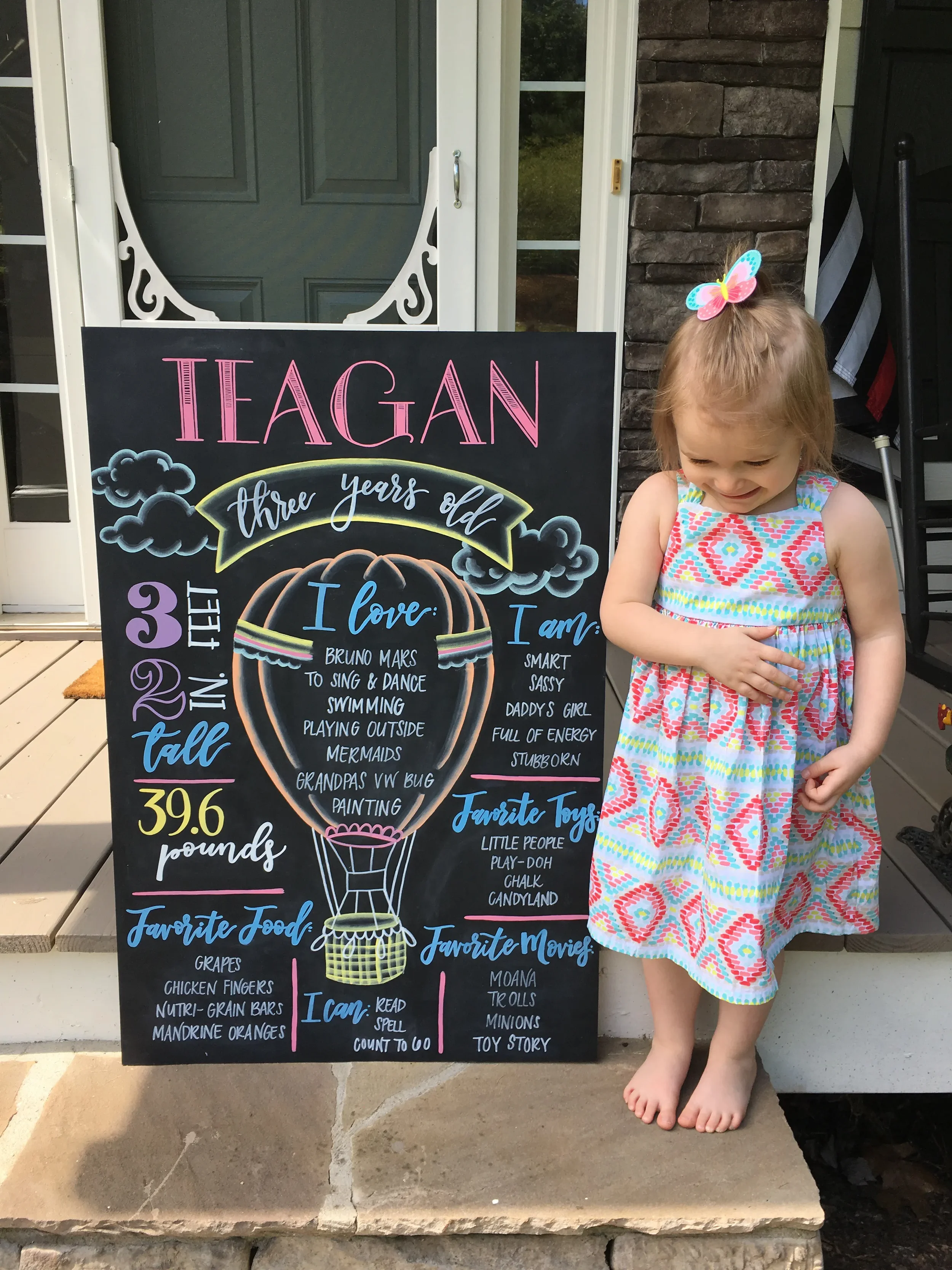 Colorful little girls hot air balloon birthday milestone chalkboard displaying stats and things they love. 