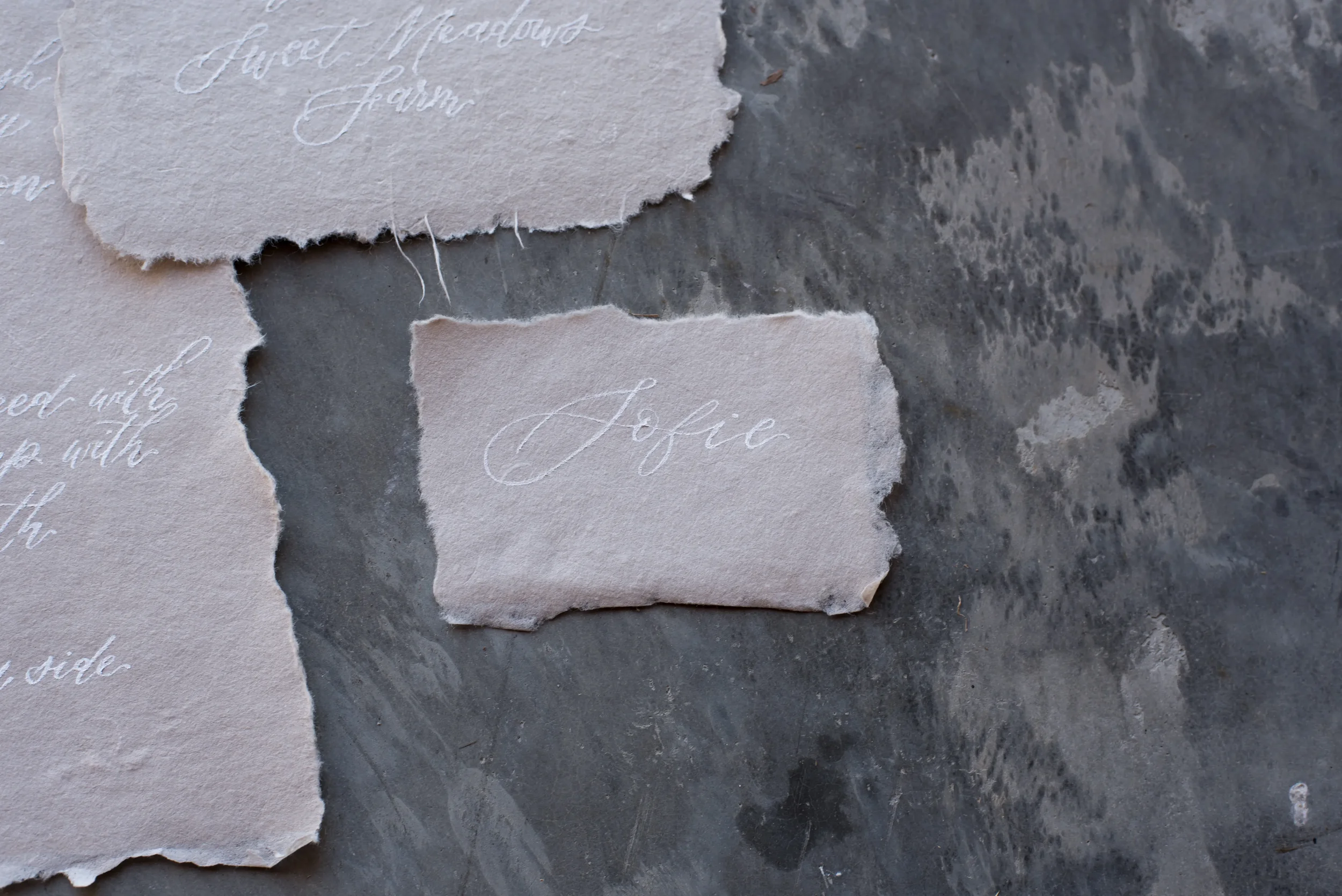 Delicate handmade paper name card written in white calligraphy ink.