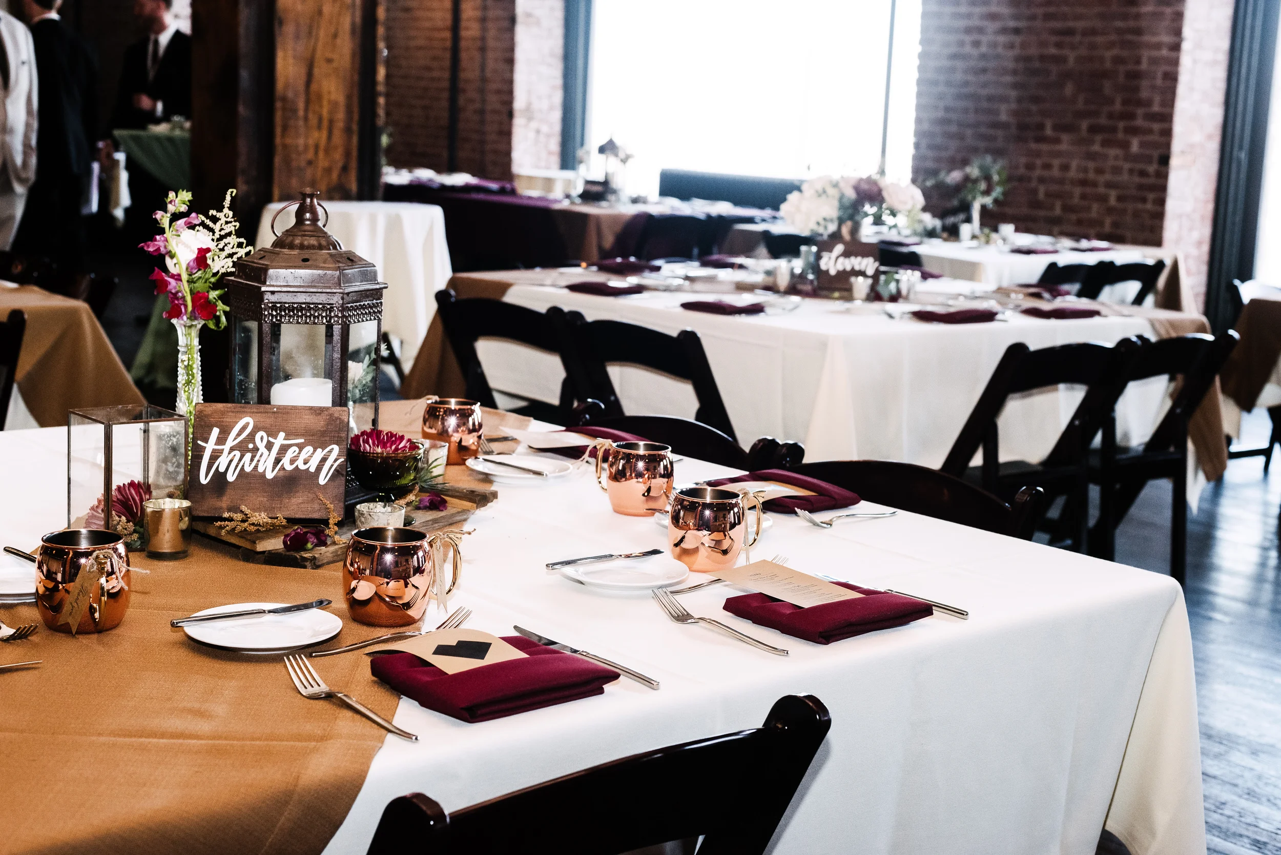 Rustic wood table number block with white hand-lettered script.