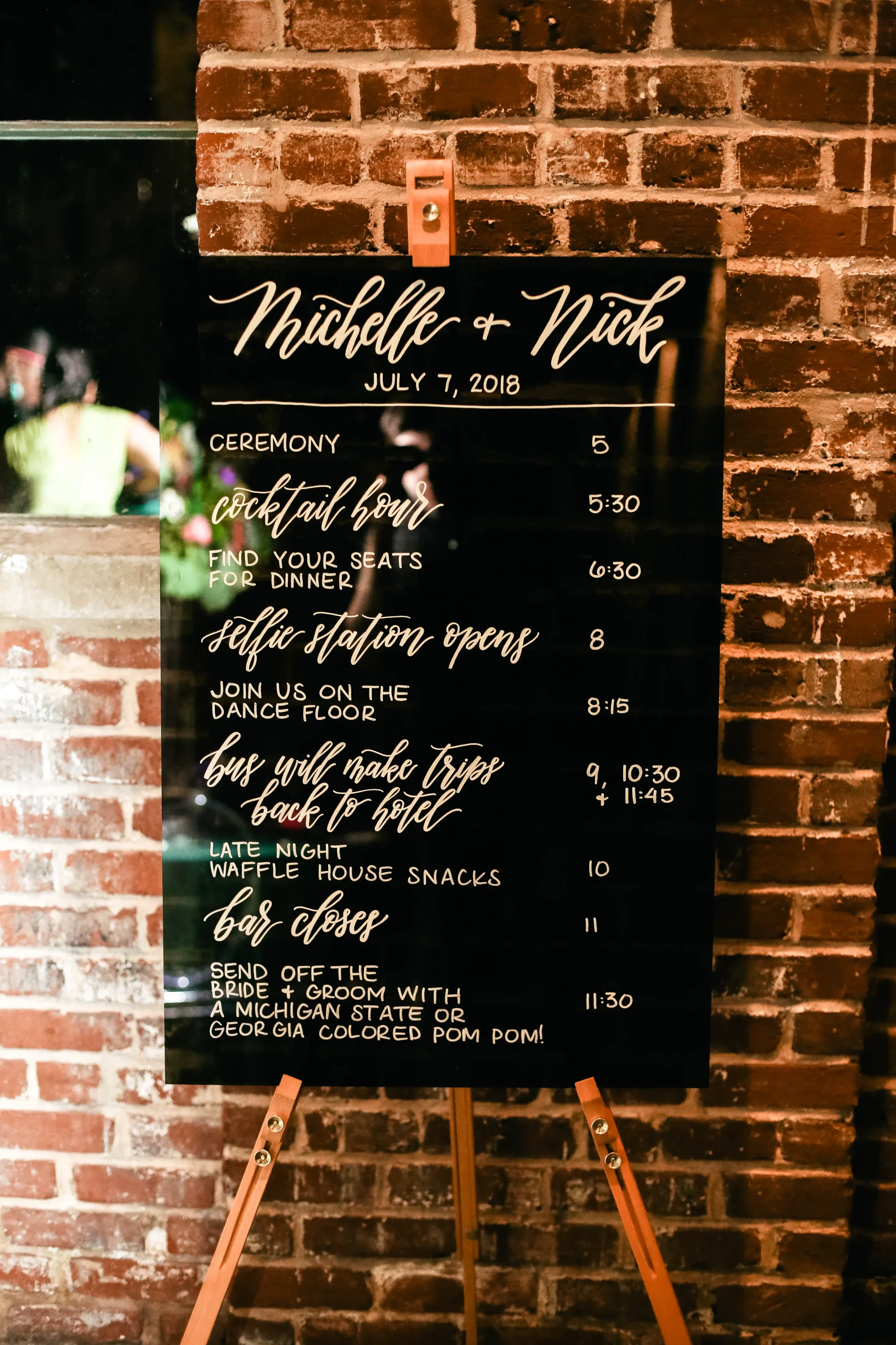 black-acrylic-wedding-timeline-schedule-sign-easel.webp