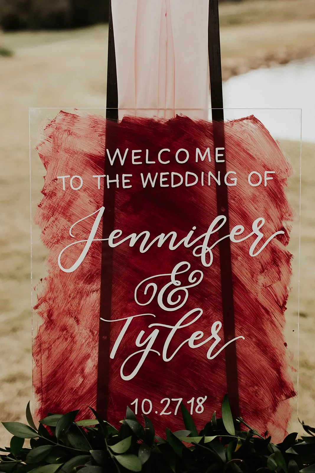Moody fall wedding welcome sign with white ink calligraphy at an outdoor Georgia venue.