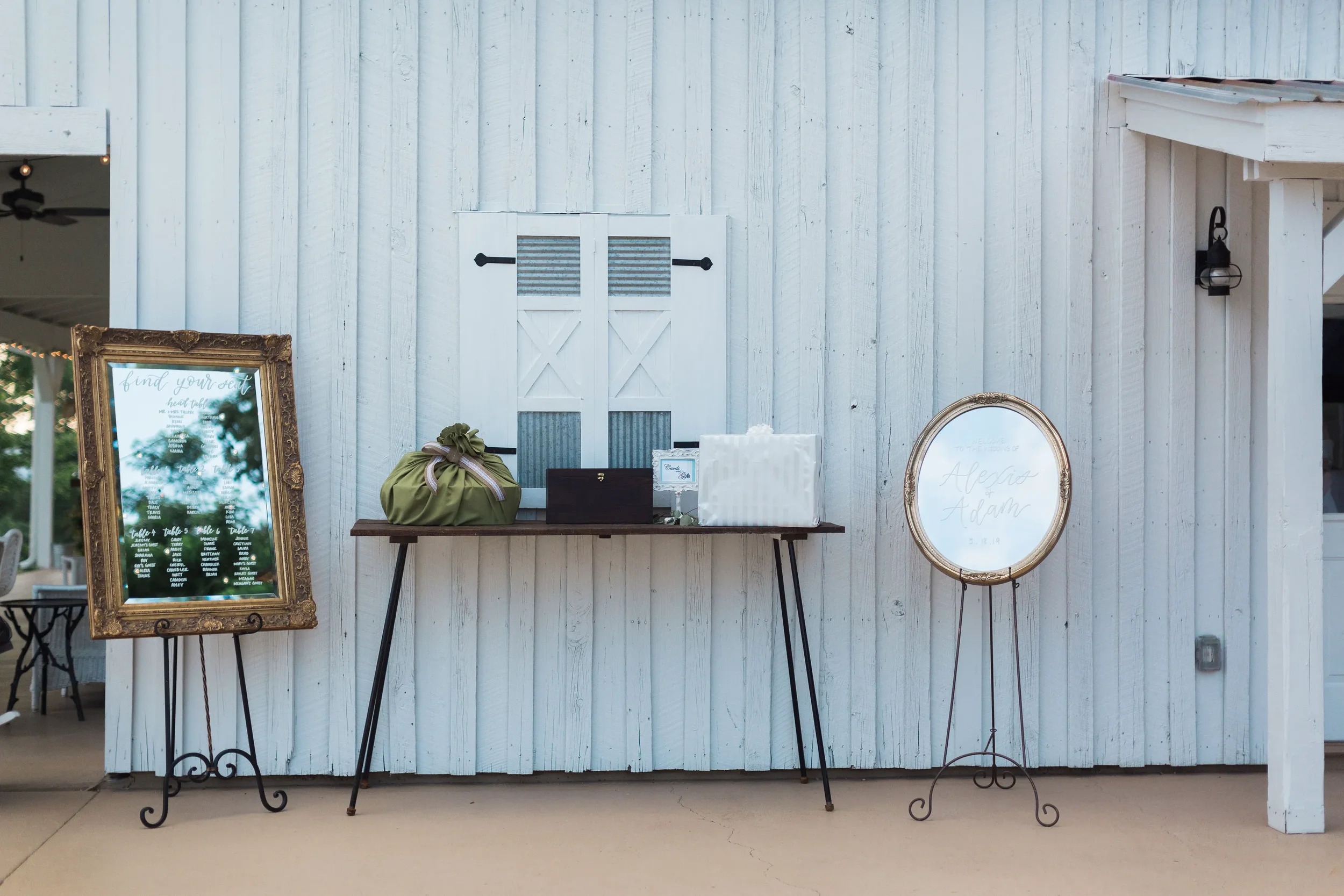 Gold vintage mirrors used as a seating chart and a welcome sign displayed on easels outdoors for an elegant southern Georgia wedding