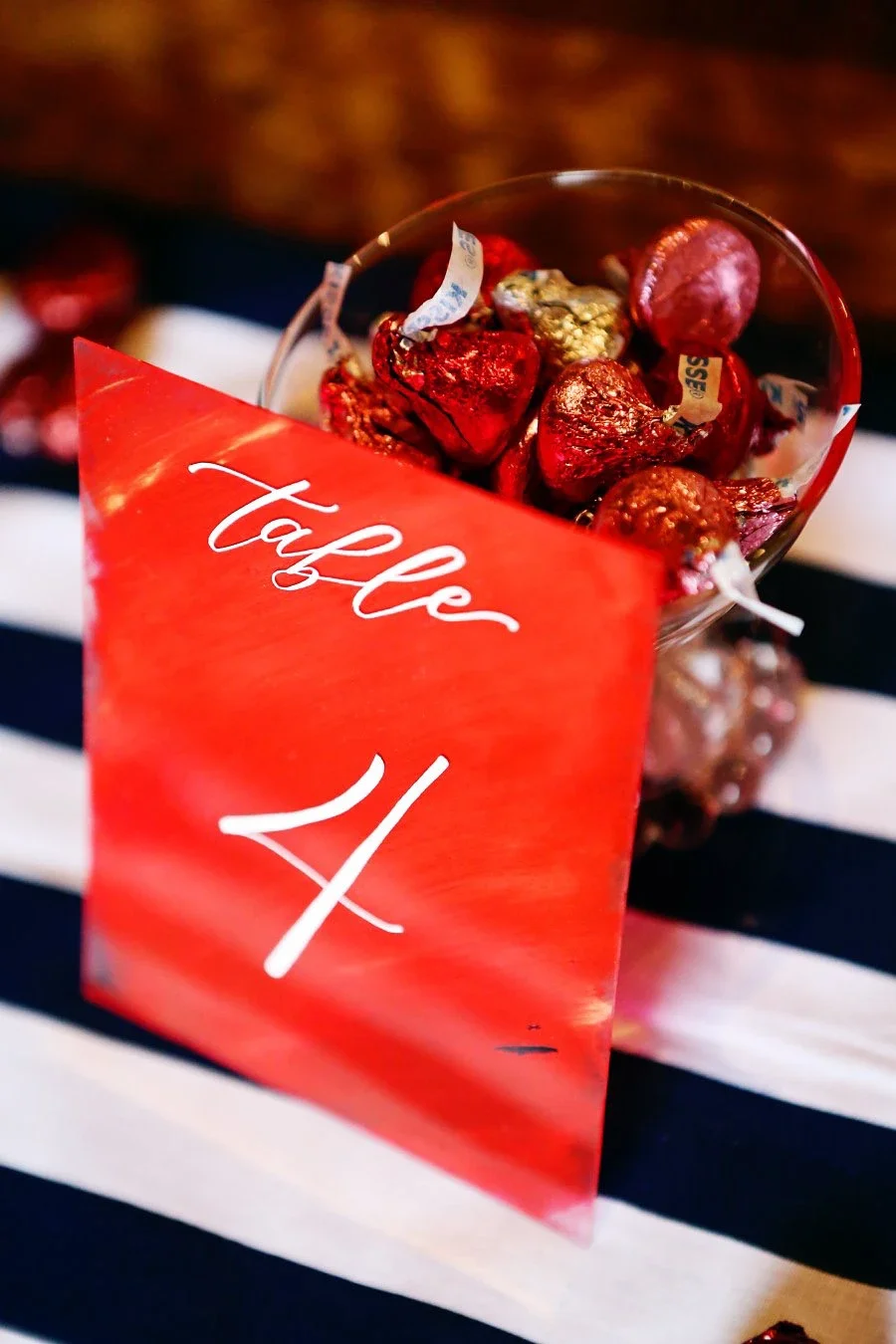Red painted back acrylic table number with white calligraphy lettering.