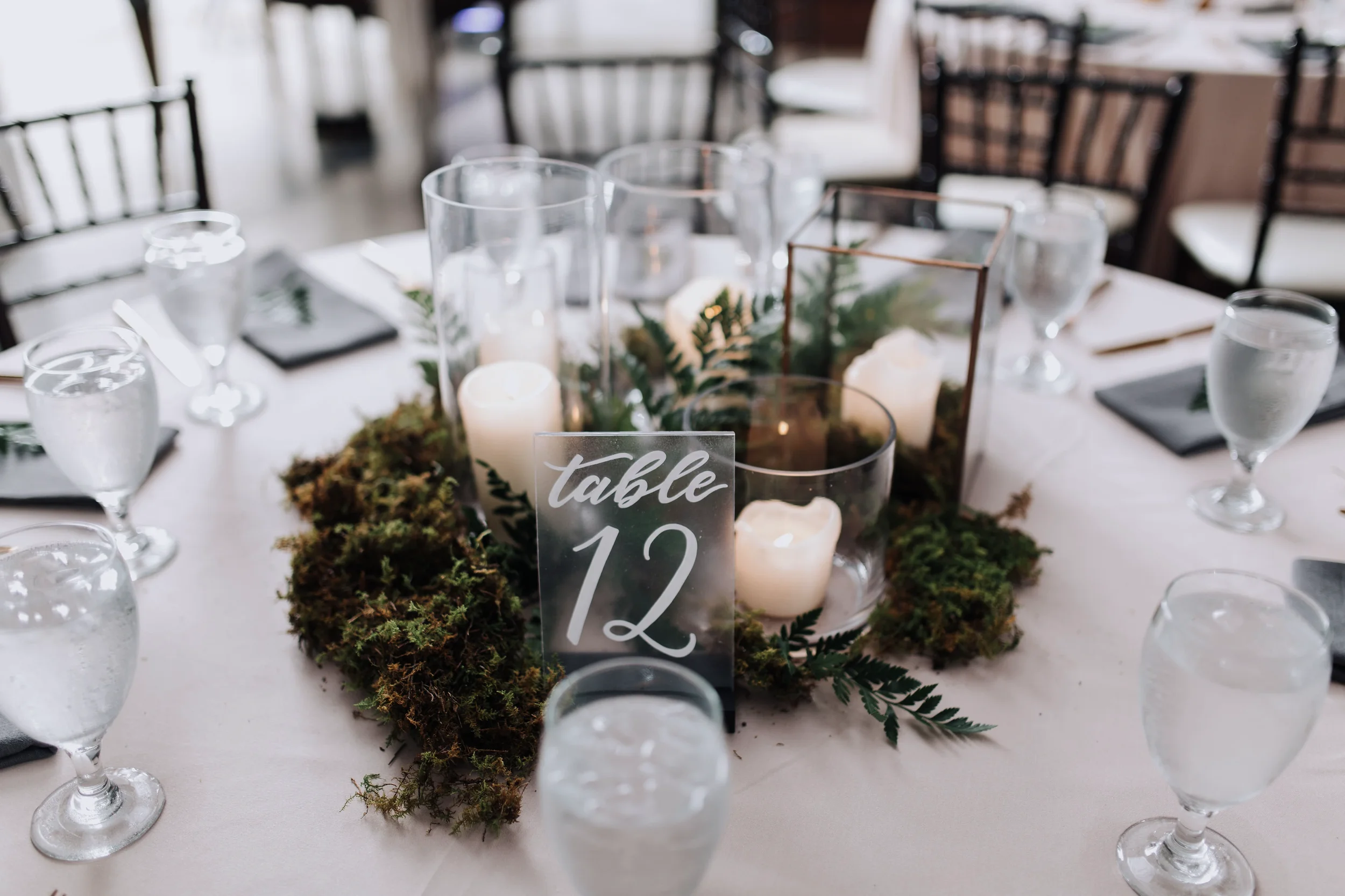 Clear acrylic wedding table numbers written in white ink script.