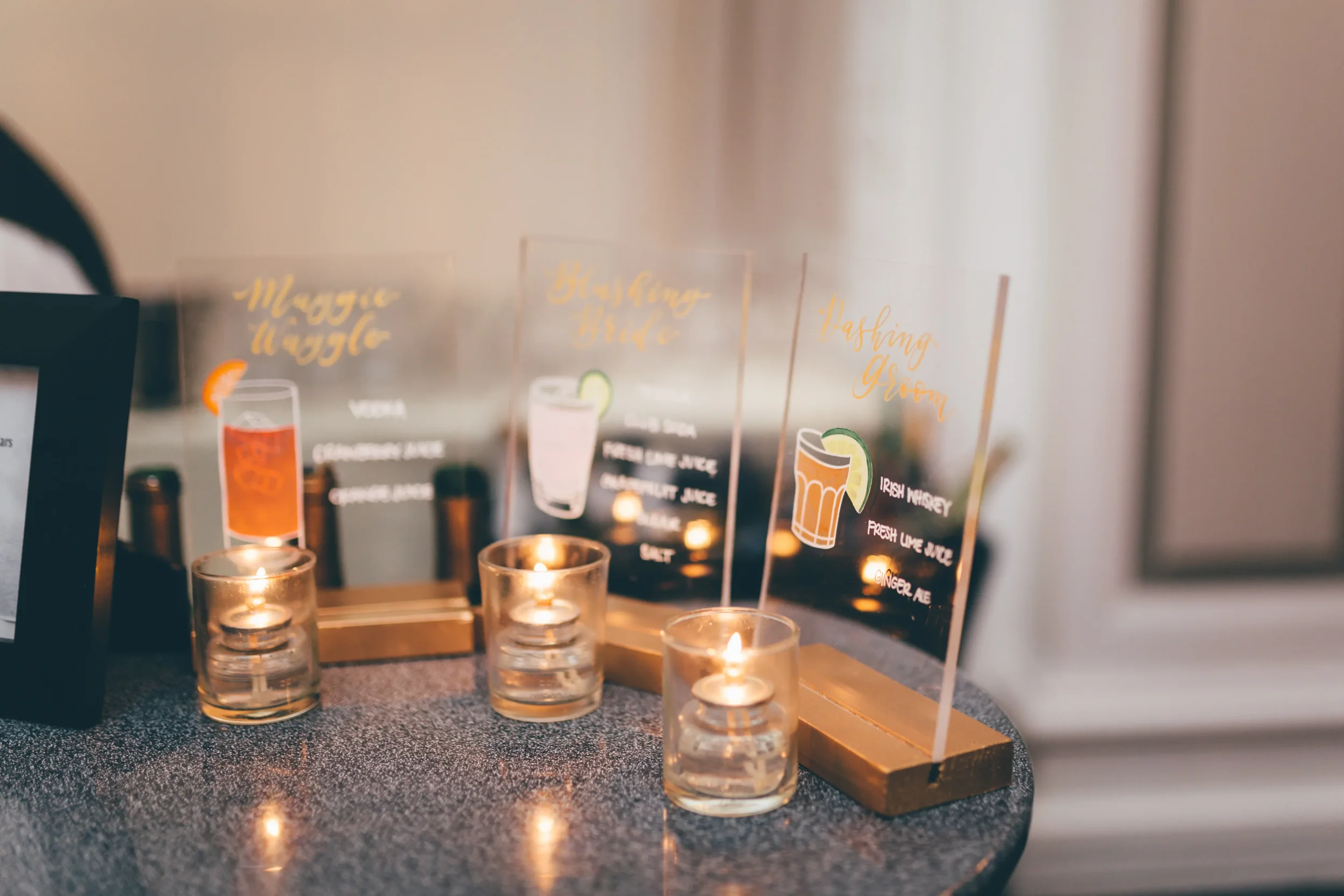 Custom acrylic bar sign with white script calligraphy and colorful cocktail graphics.