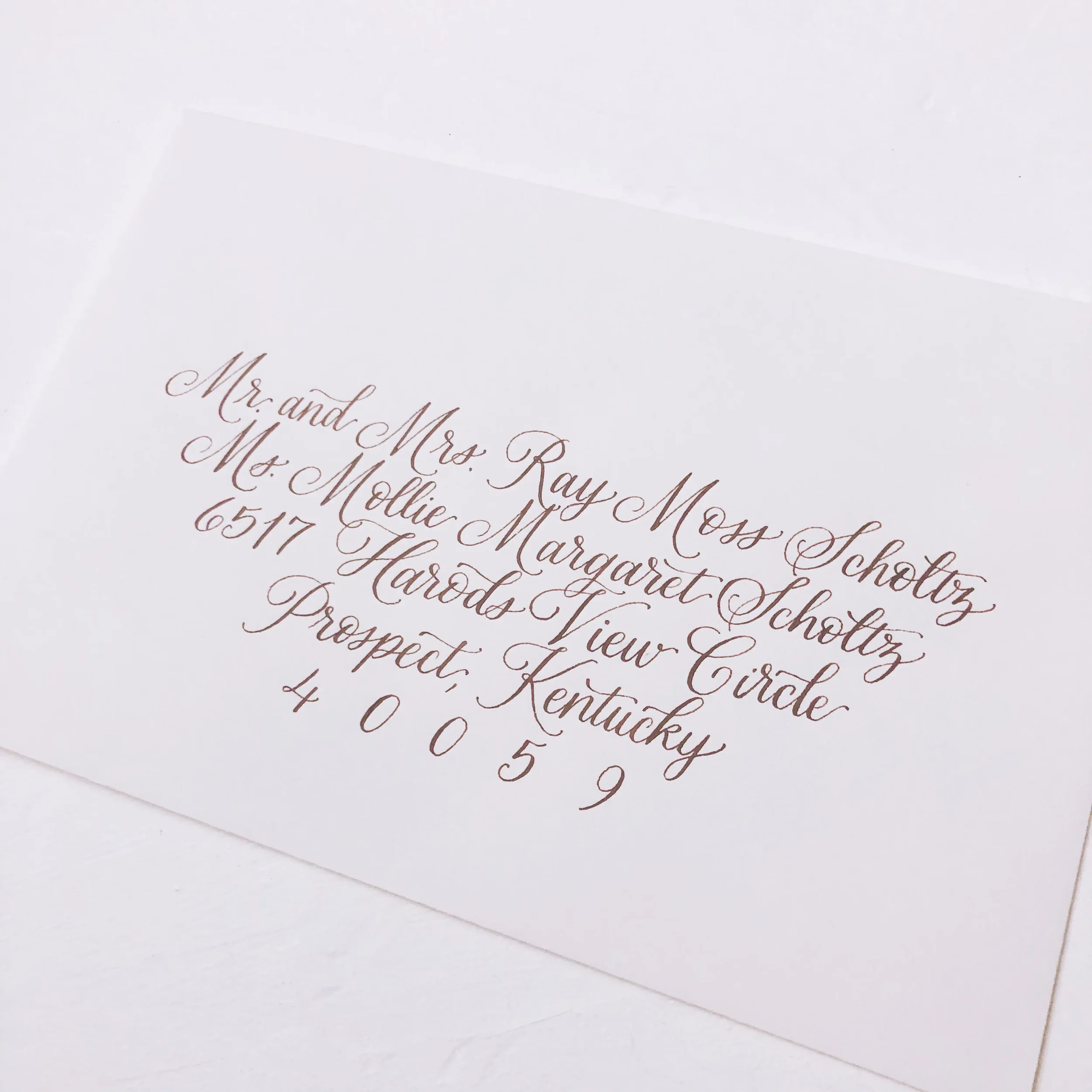 For couples who adore traditional, fine-art design, this stack of cream-colored envelopes features refined sepia brown calligraphy. The precise layout, sweeping zip codes, and classic script fonts emphasize an heirloom-quality execution that sets a l