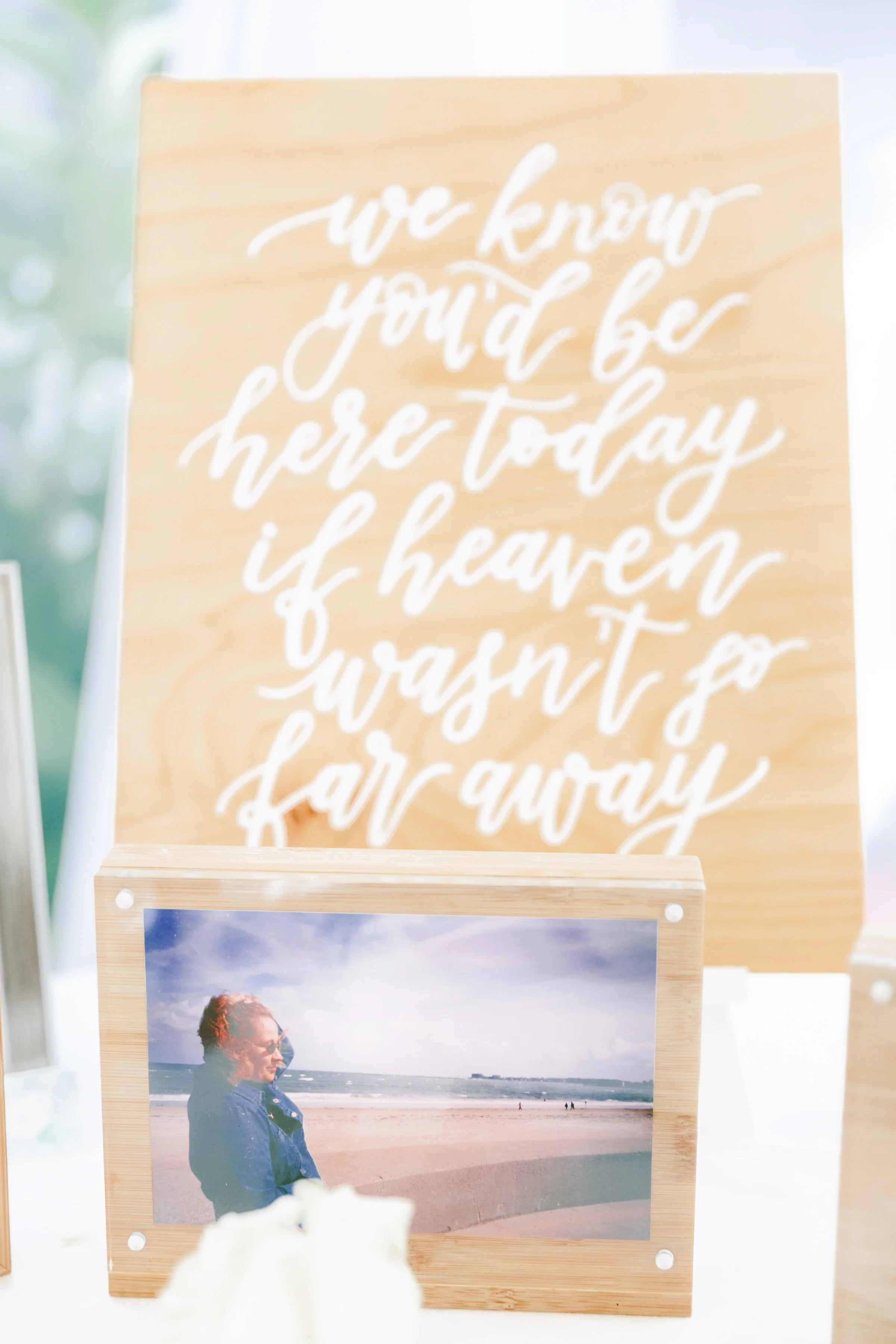 Honor loved ones missing from your big day with a thoughtful wooden memorial table sign. Hand-lettered in gentle white calligraphy script on a light natural wood panel, this piece brings a sweet, loving touch to your memory table set-up.