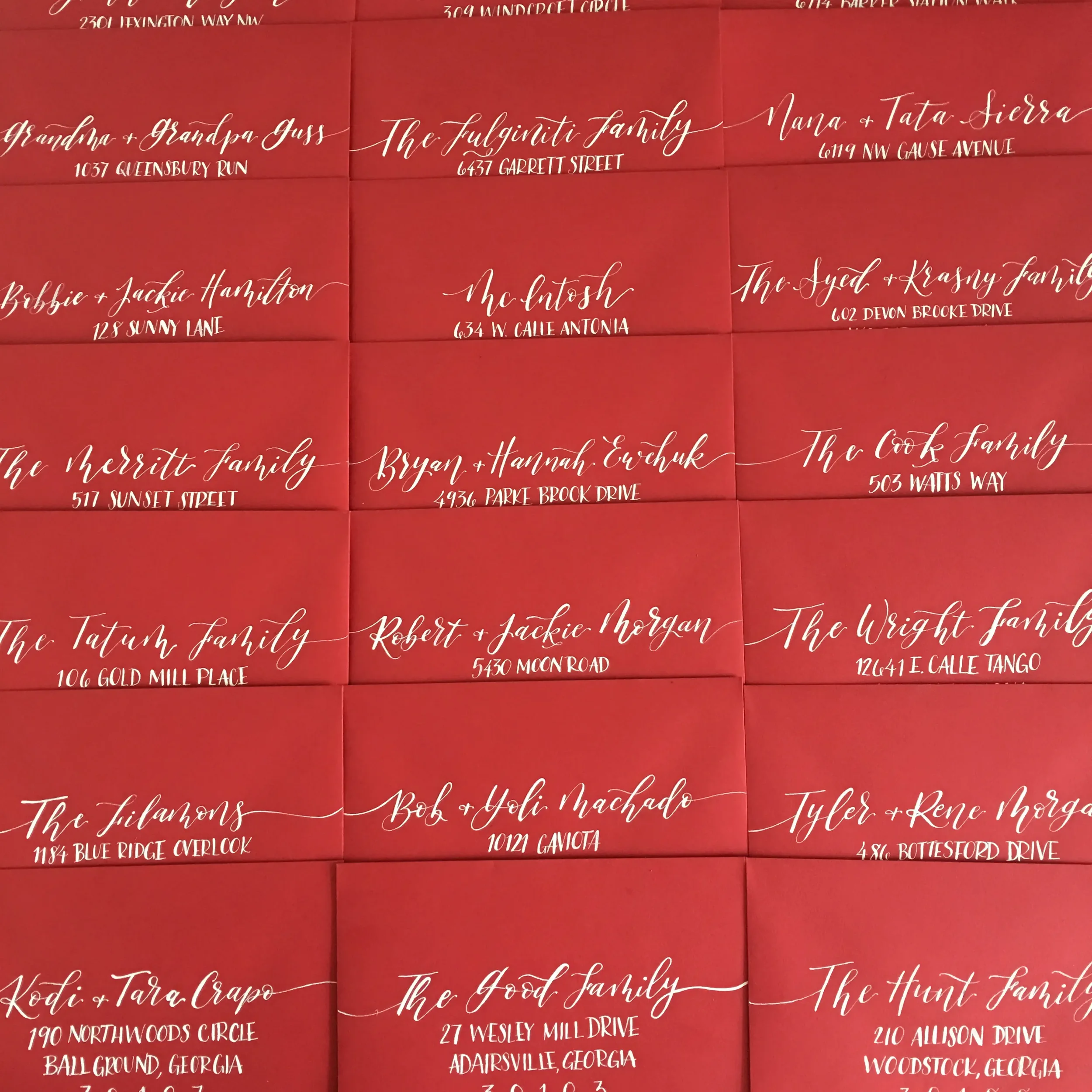 Bold crimson red acrylic wedding invitation with white calligraphy addressing.