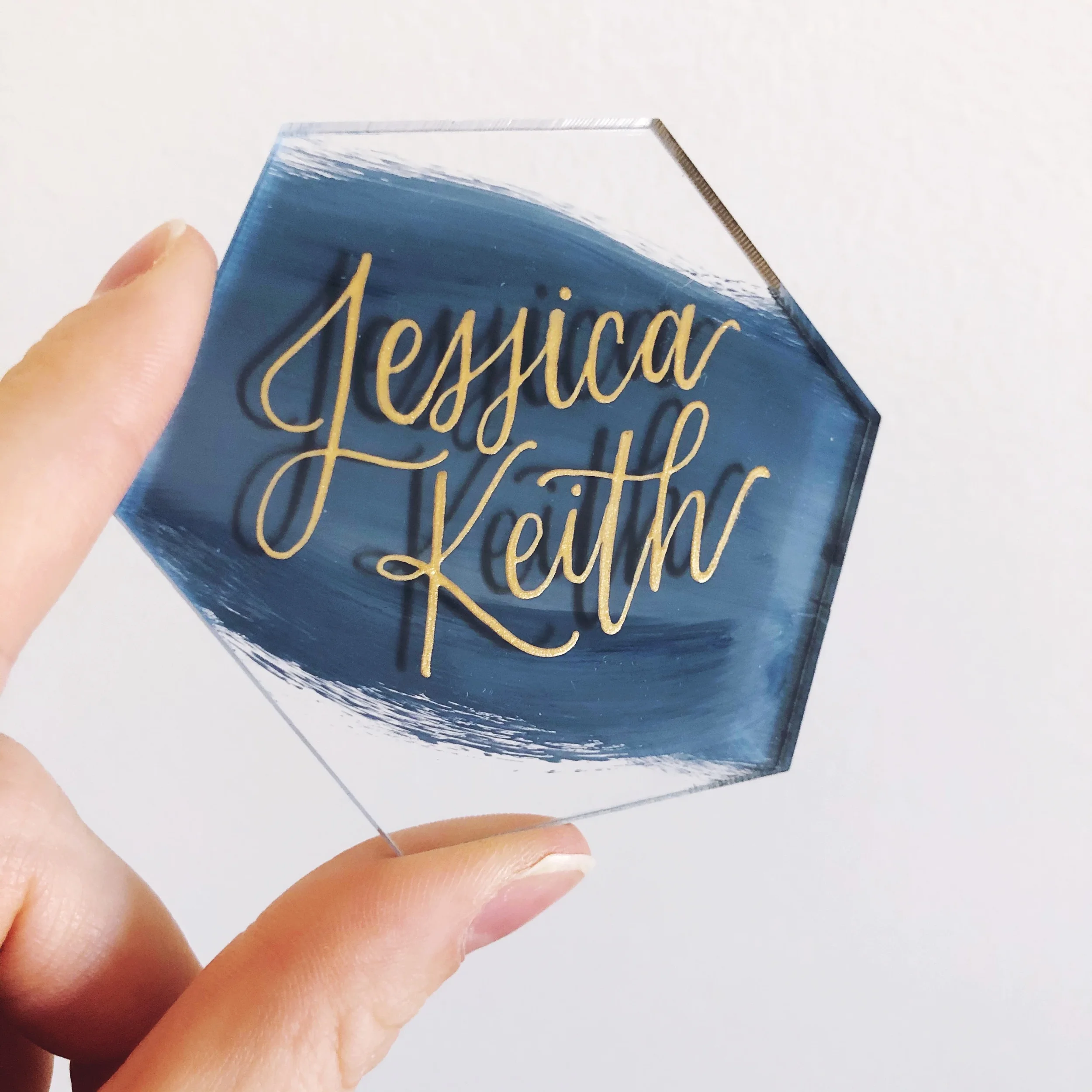 Modern navy brushed back acrylic hexagon tile wedding escort cards featuring reflective metallic gold hand-lettering.