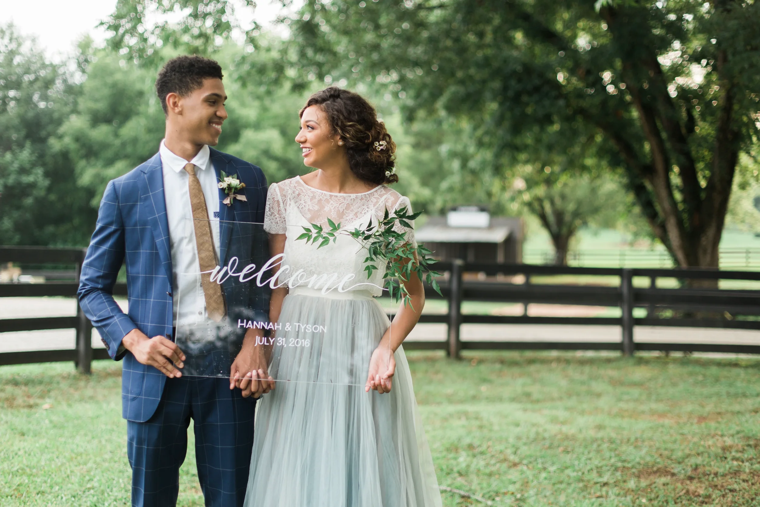 Modern transparent acrylic wedding welcome sign featuring elegant hand-lettered names.
