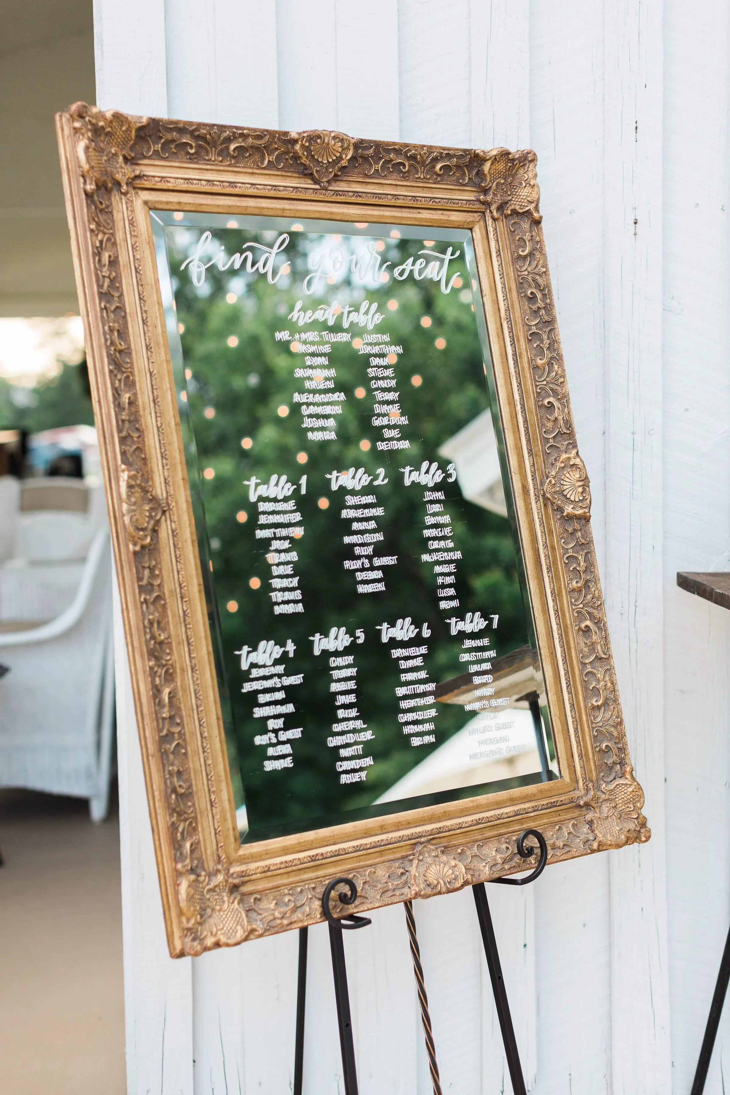Make a stunning statement at your reception entrance with a custom calligraphy mirror seating chart. Hand-lettered on a beautiful vintage ornate gold frame, this functional decor piece guides your guests to their tables while adding a touch of timele