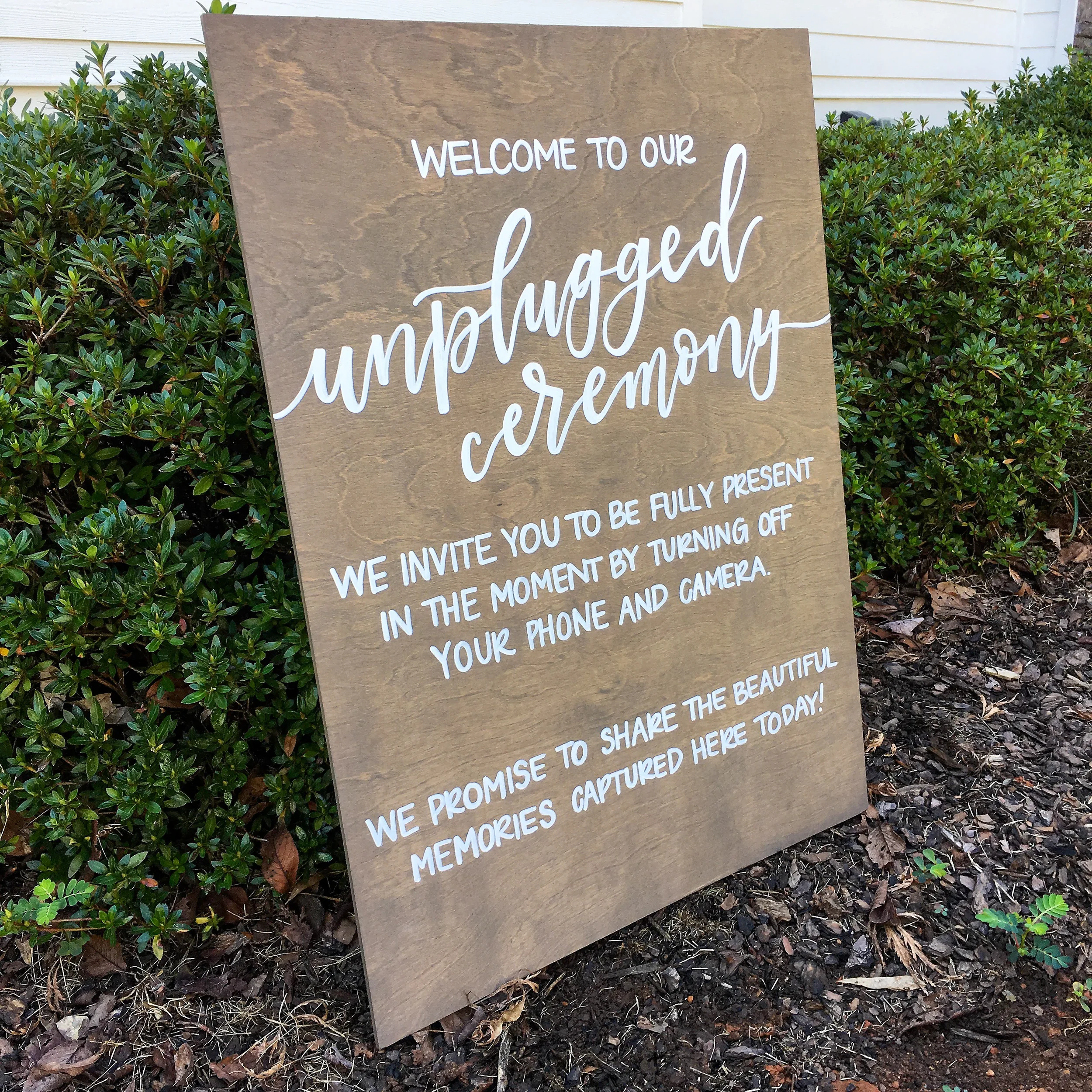 Rustic outdoor wooden unplugged ceremony sign asking guests to turn off phones and cameras.