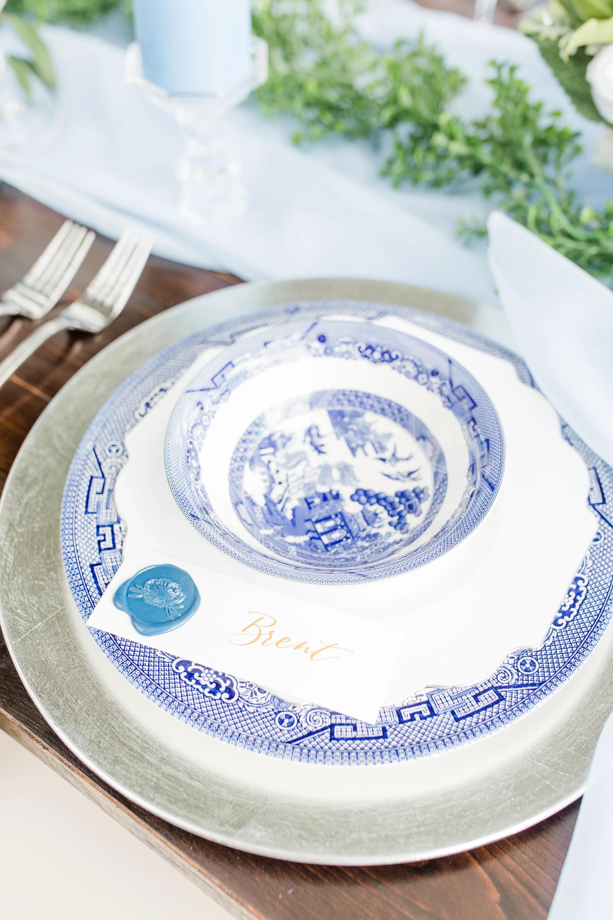 Traditional blue and white pattern china bowl with a blue wax seal name card lettered in gold script.