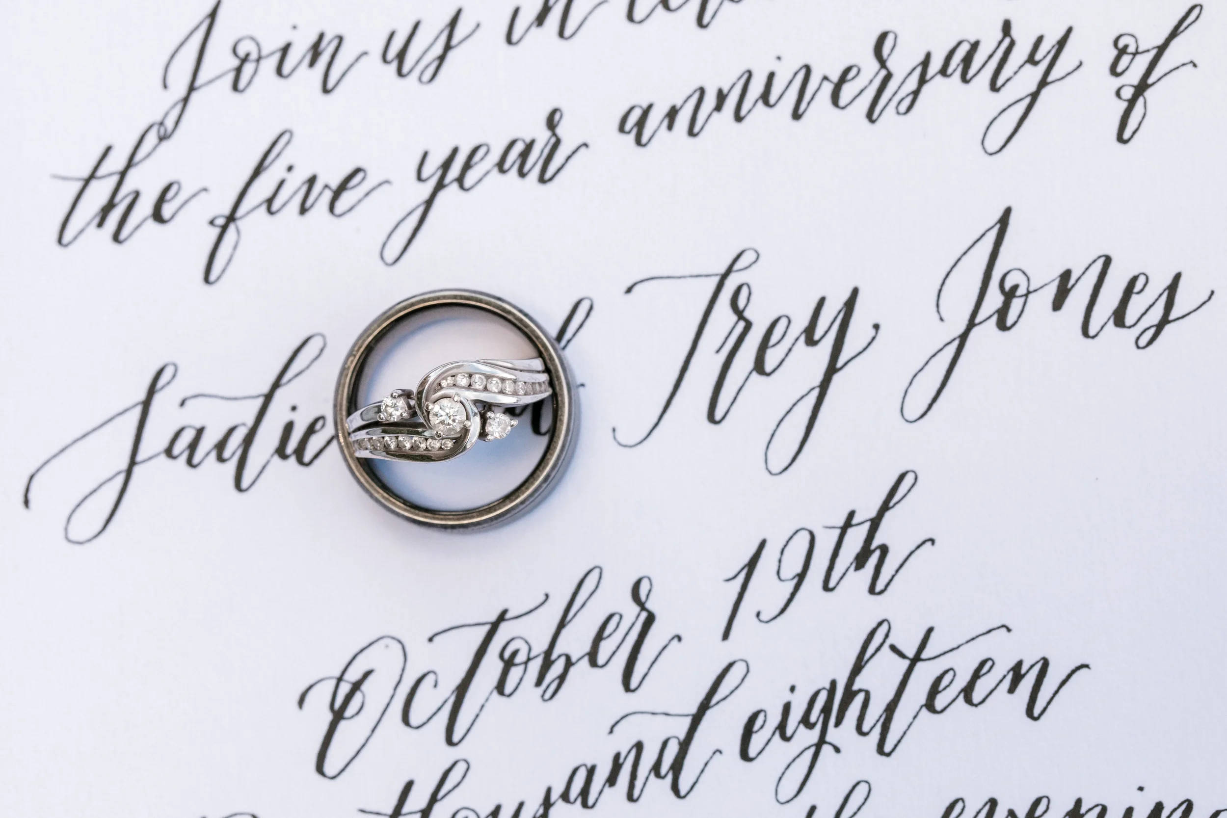 Formal five-year anniversary invitation card featuring elegant black script calligraphy and a diamond ring.