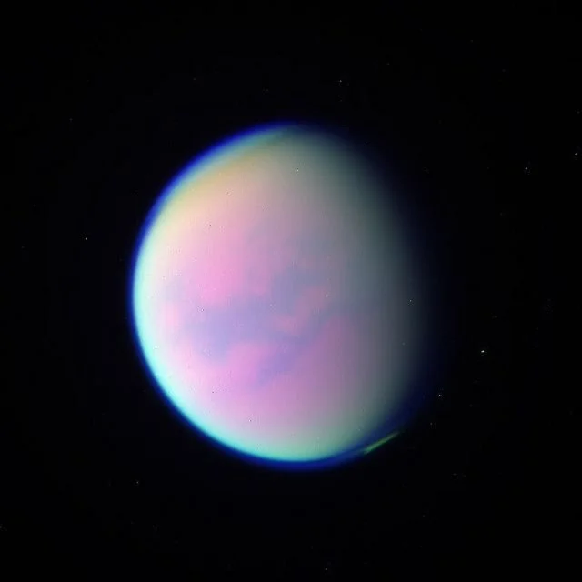 Colorful planet with a smooth surface, featuring pink, purple, and blue hues, set against a black space background with small stars.