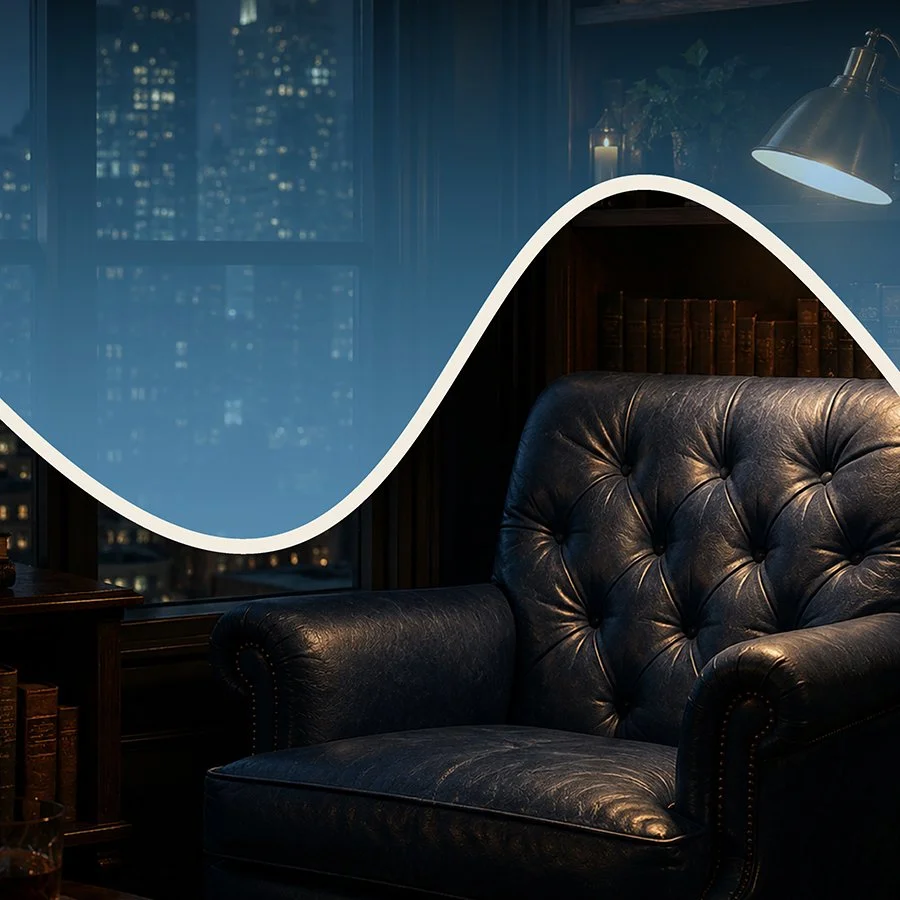 A cozy room with a black leather armchair, a reading lamp, and a bookshelf with old books, with large windows showing a city skyline at night.