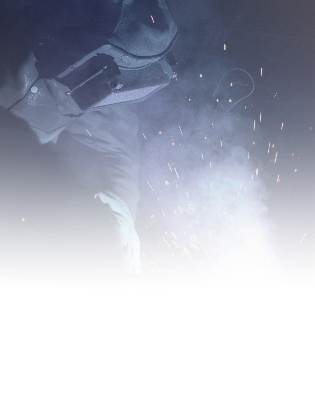 A person welding metal, with sparks and smoke around.