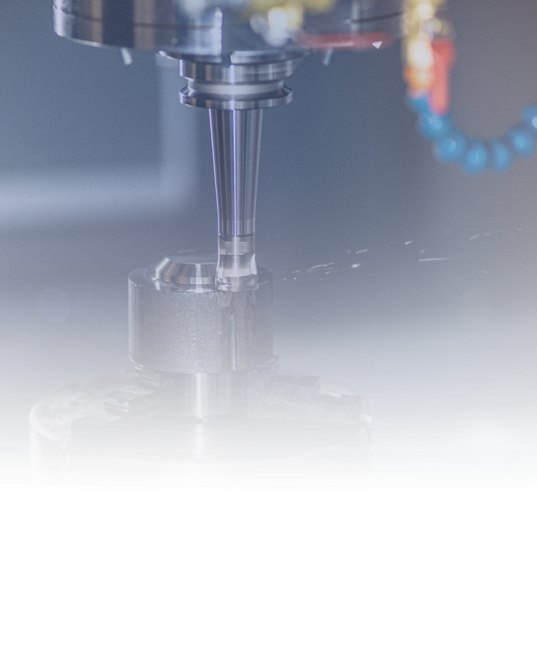 Close-up of a CNC machine drill bit machining a metal workpiece in a manufacturing setting.