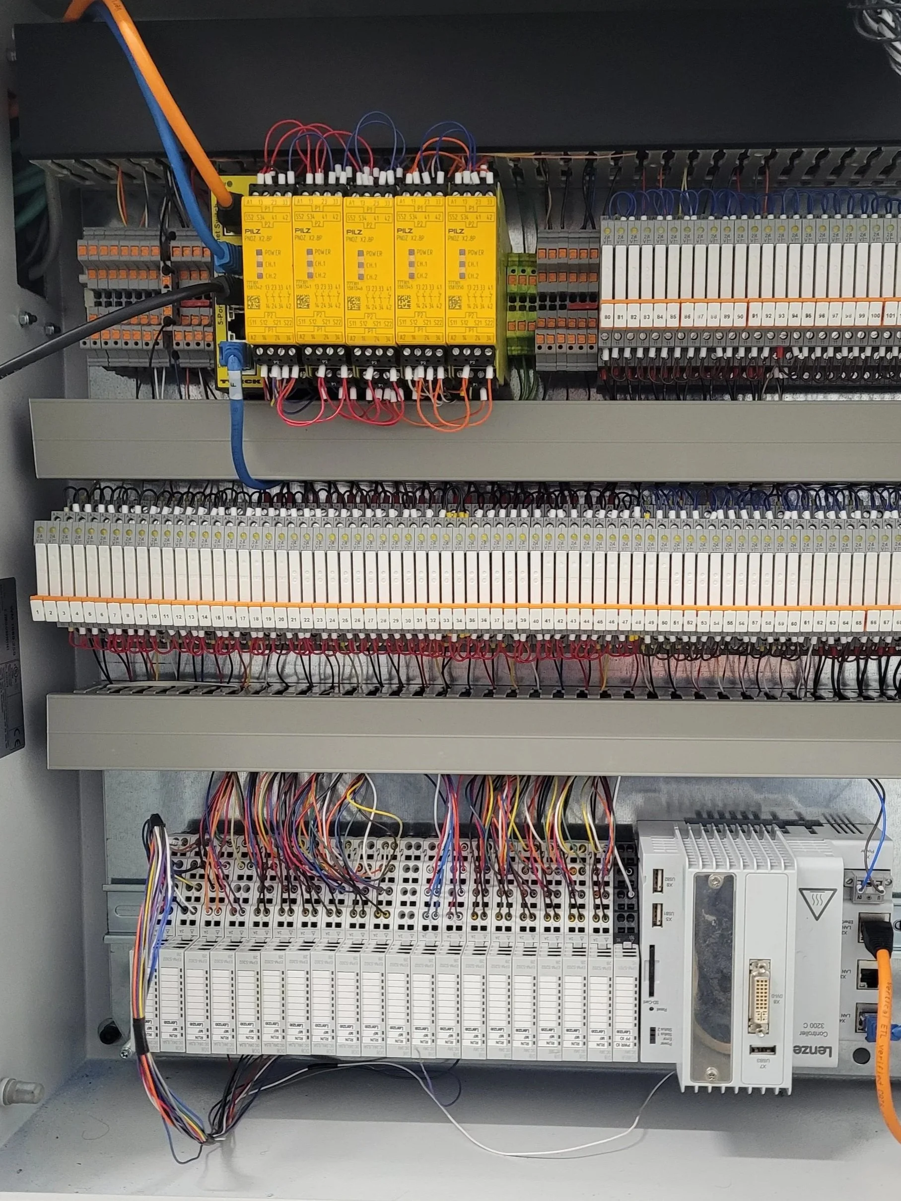Electrical control panel with wiring, circuit boards, relays, and programmable logic controllers.