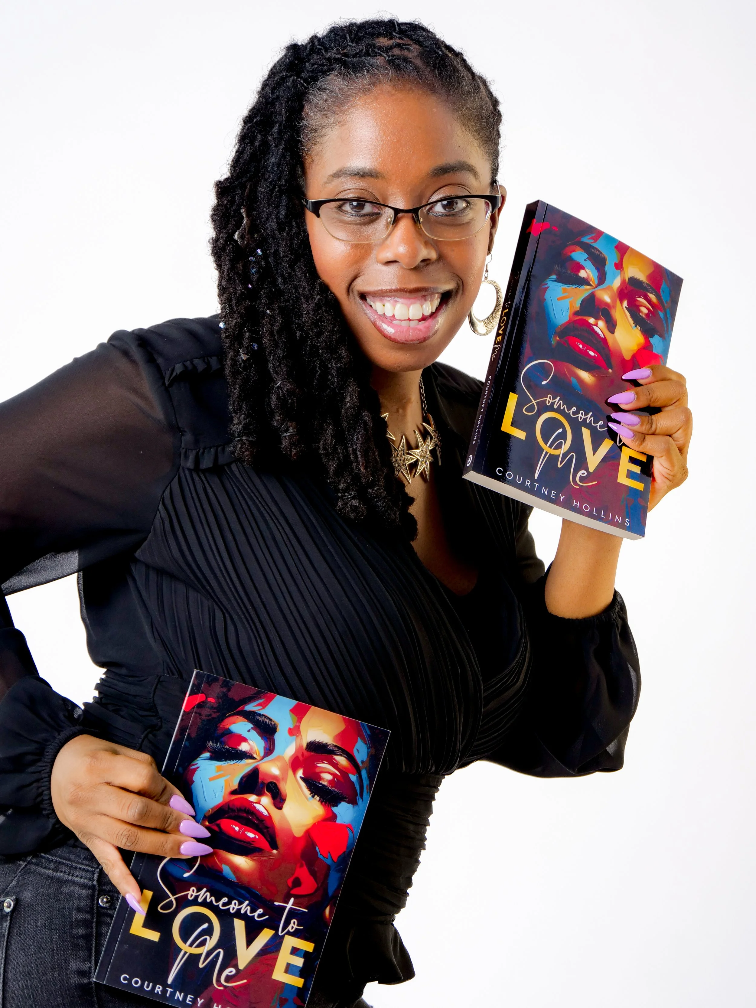 A phenomenal woman with a burst of energy holding books titled 'Someone to Love Me,' a new take on romance by Courtney Hollins