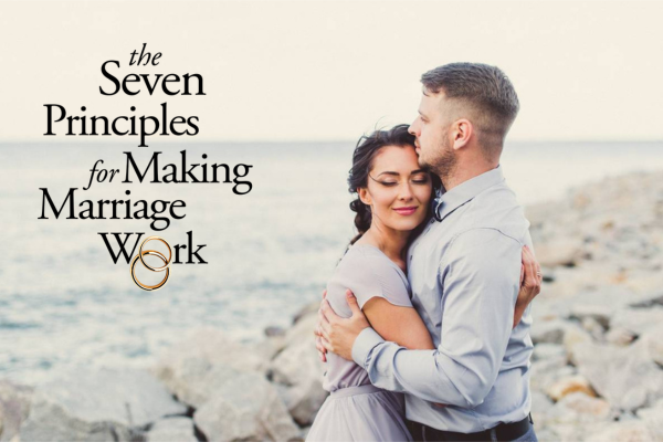A couple hugging on a rocky beach with a book titled 'The Seven Principles for Making Marriage Work' in the foreground.