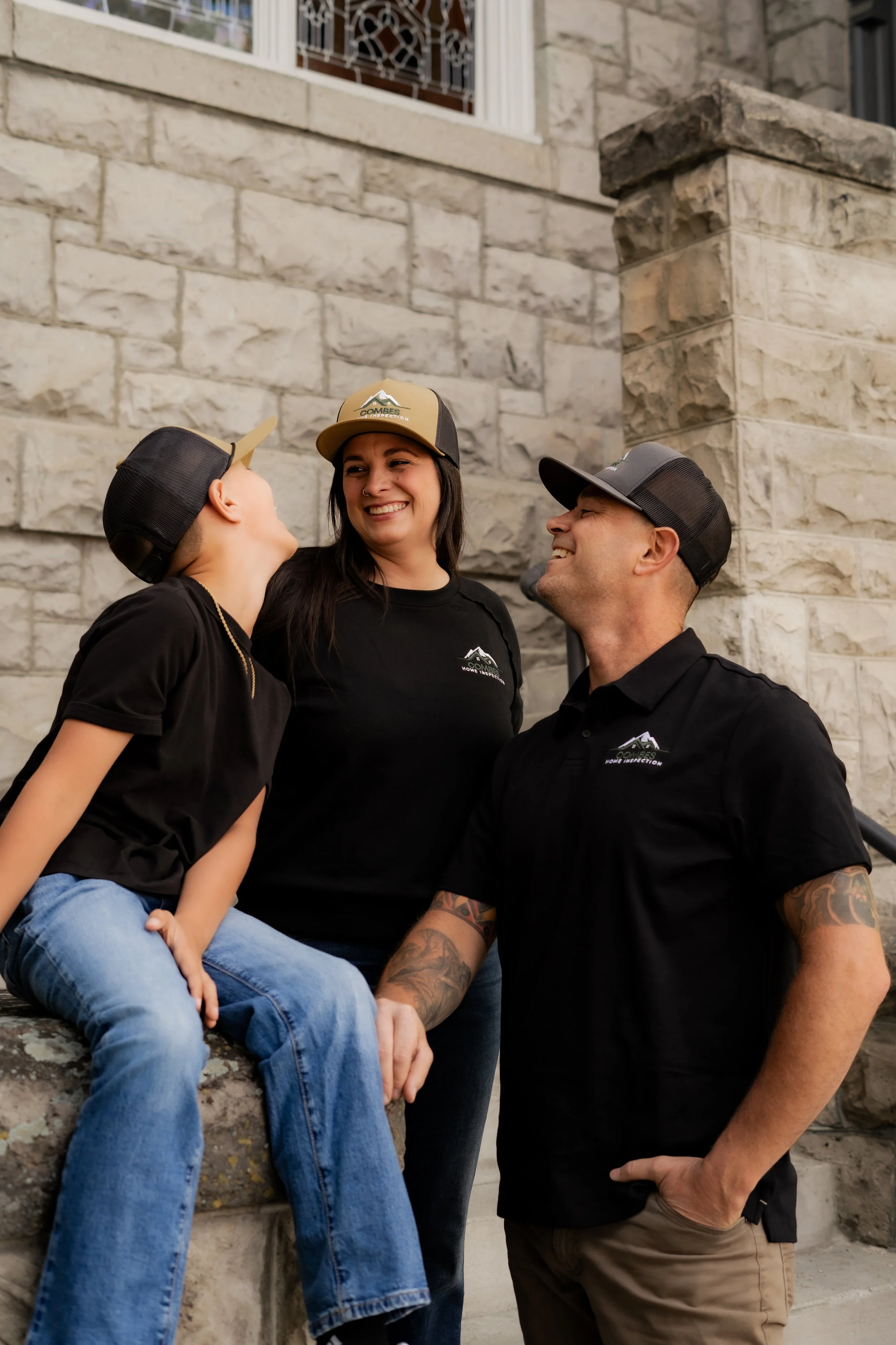 Sebastian Combes and family laughing and wearing Combes Home Inspection hats.