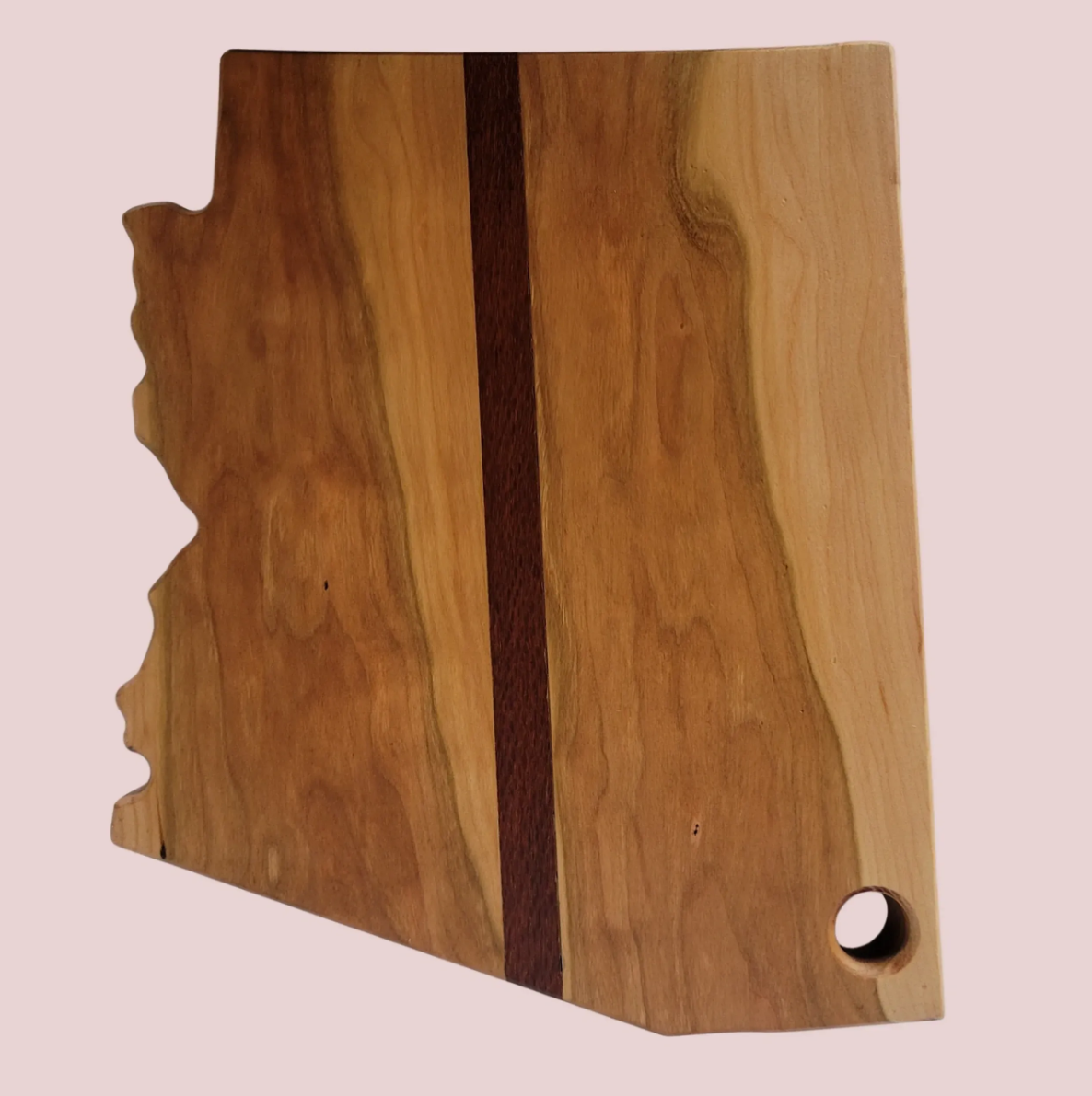 Wooden box with a circular hole on the right side and a decorative edge on the left, set against a pink background.