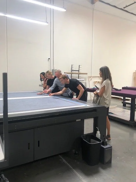General Public team and guest inspecting printed artwork live on a printer. 