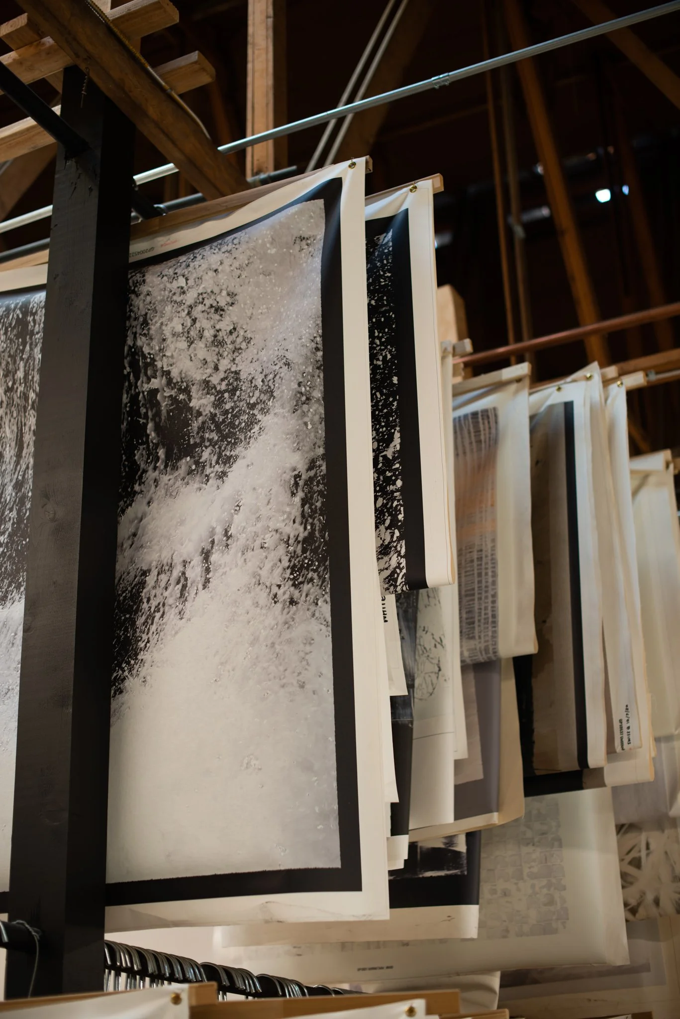 Hanging canvas art replicas hanging to dry on the General Public manufacturing floor. 
