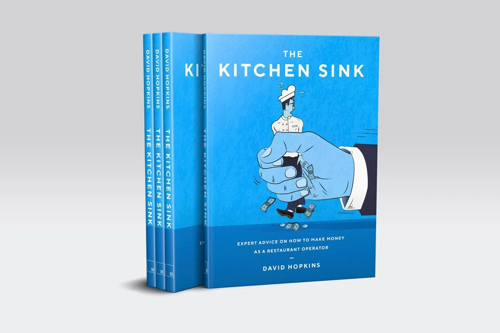 A stack of "The Kitchen Sink" books showing the cover illustration of a chef in the grasp of a large hand in a suit, with dollars and coins being shaken out of the chef's coat.