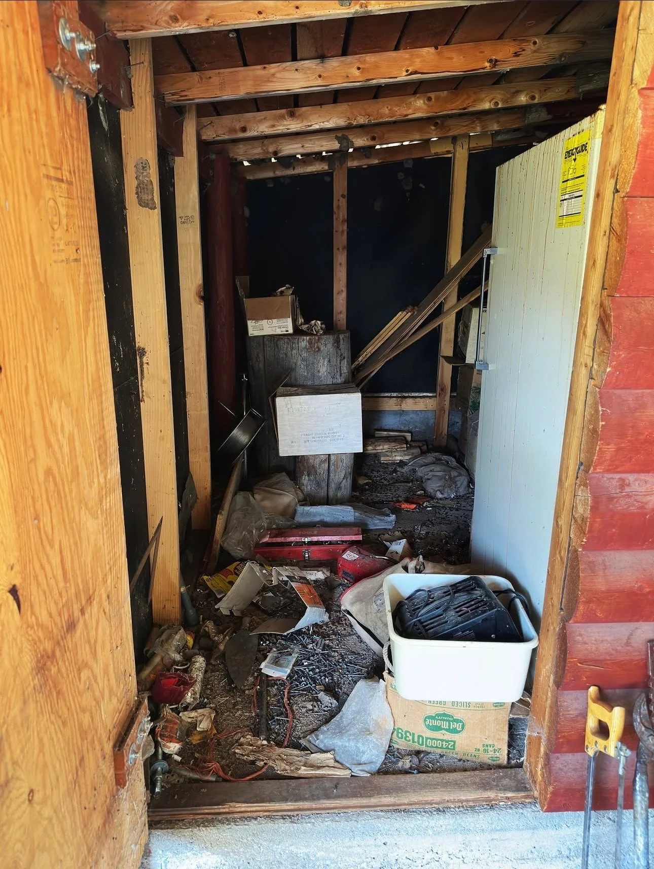 A cluttered and messy construction area with scattered tools, debris, and unfinished wooden framing, indicating ongoing or abandoned carpentry work.