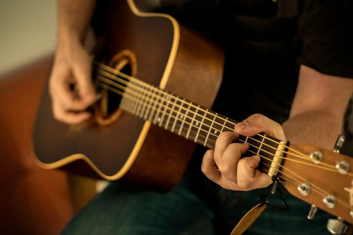 Close-up of hands playing acoustic guitar during a third Friday music night at The Living Room, Henniker NH