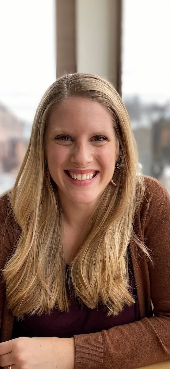 Jaime McHale smiling in a close portrait against a neutral background.