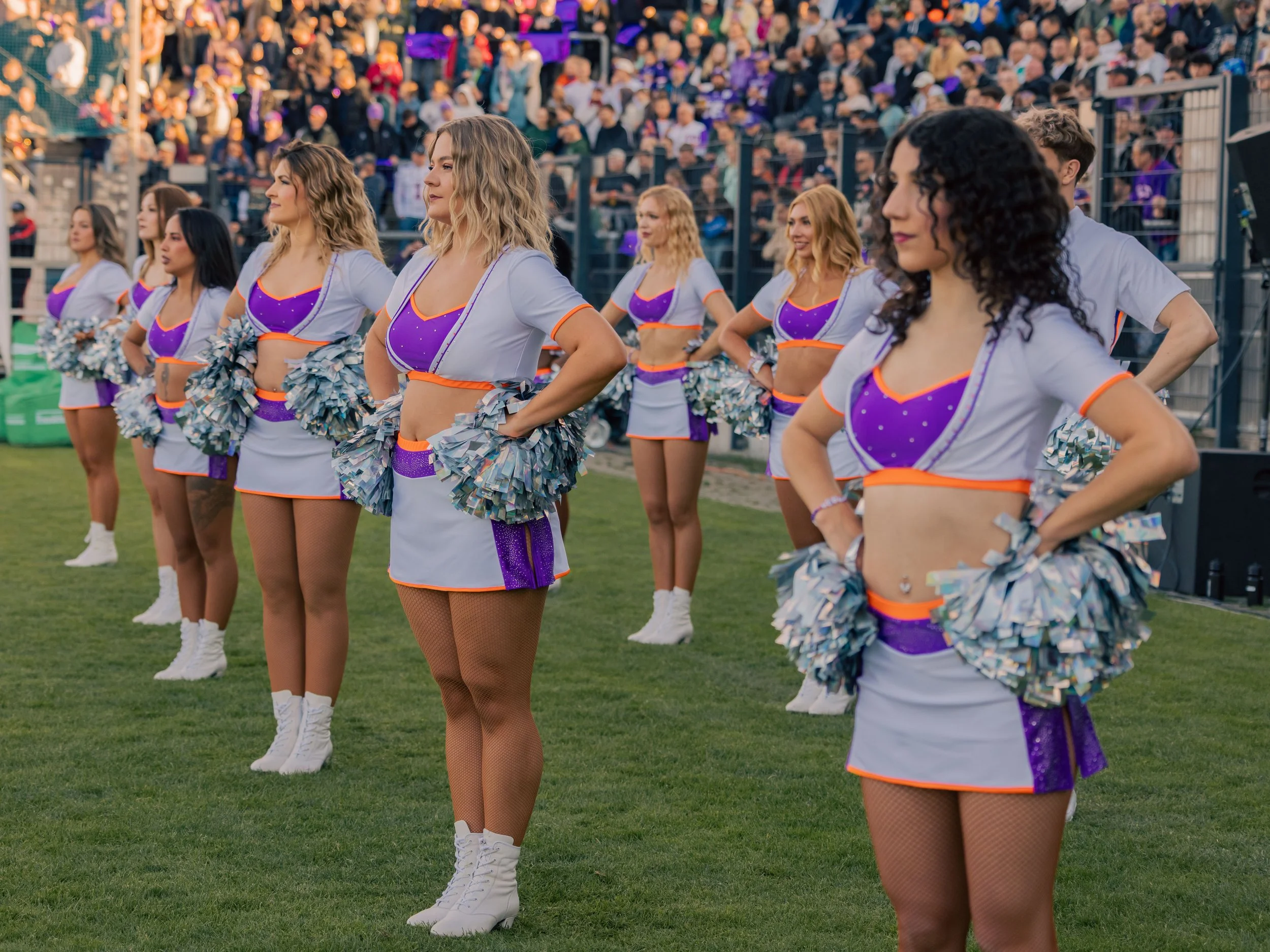 Cheerleader beim Stadion-Auftritt auf dem Rasen, im Hintergrund steht ein großes Publikum. Sportfotografie bei der Frankfurt Galaxy.