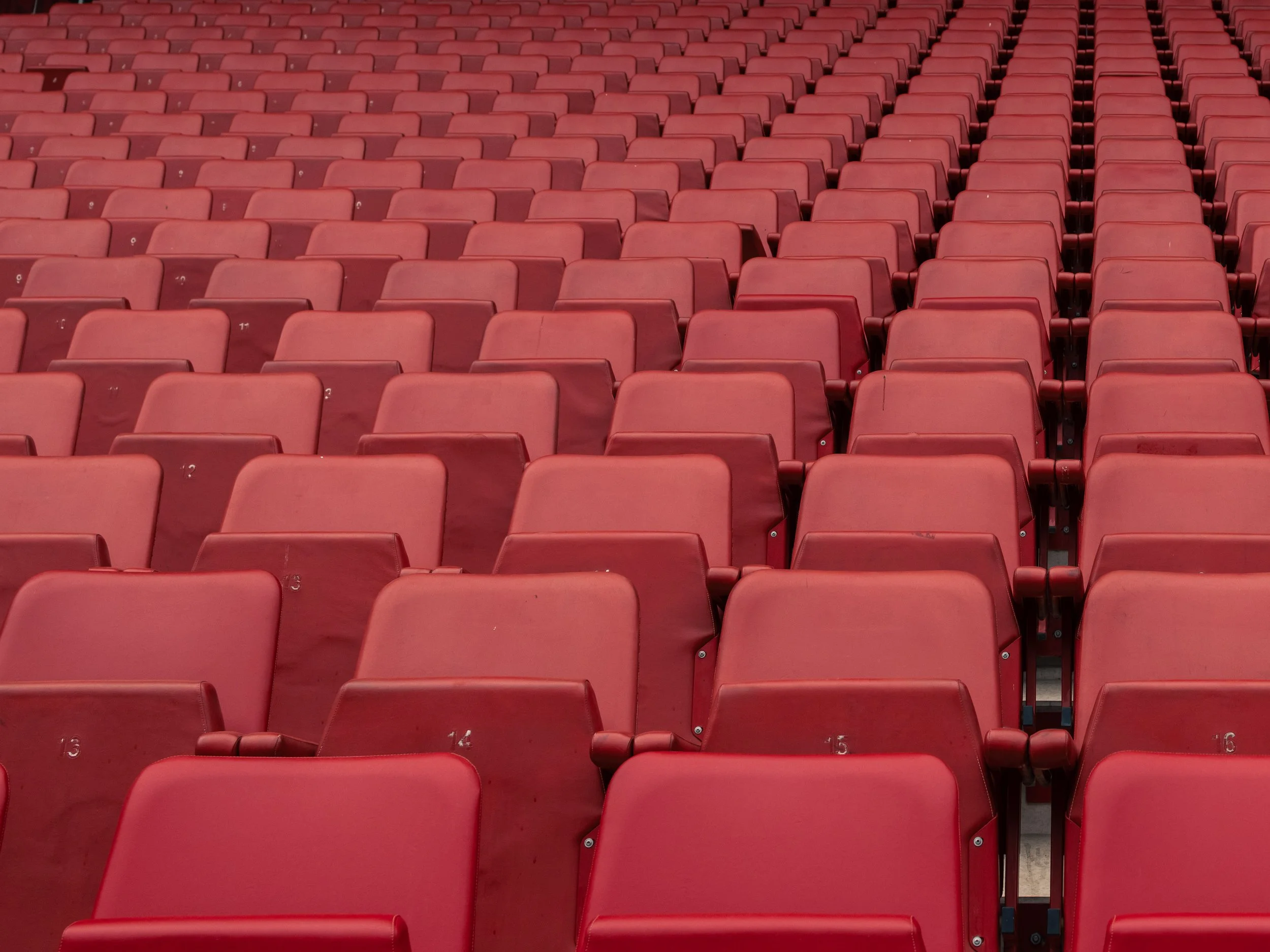 Leere rote Sitzreihen in einem Bundesliga-Stadion.